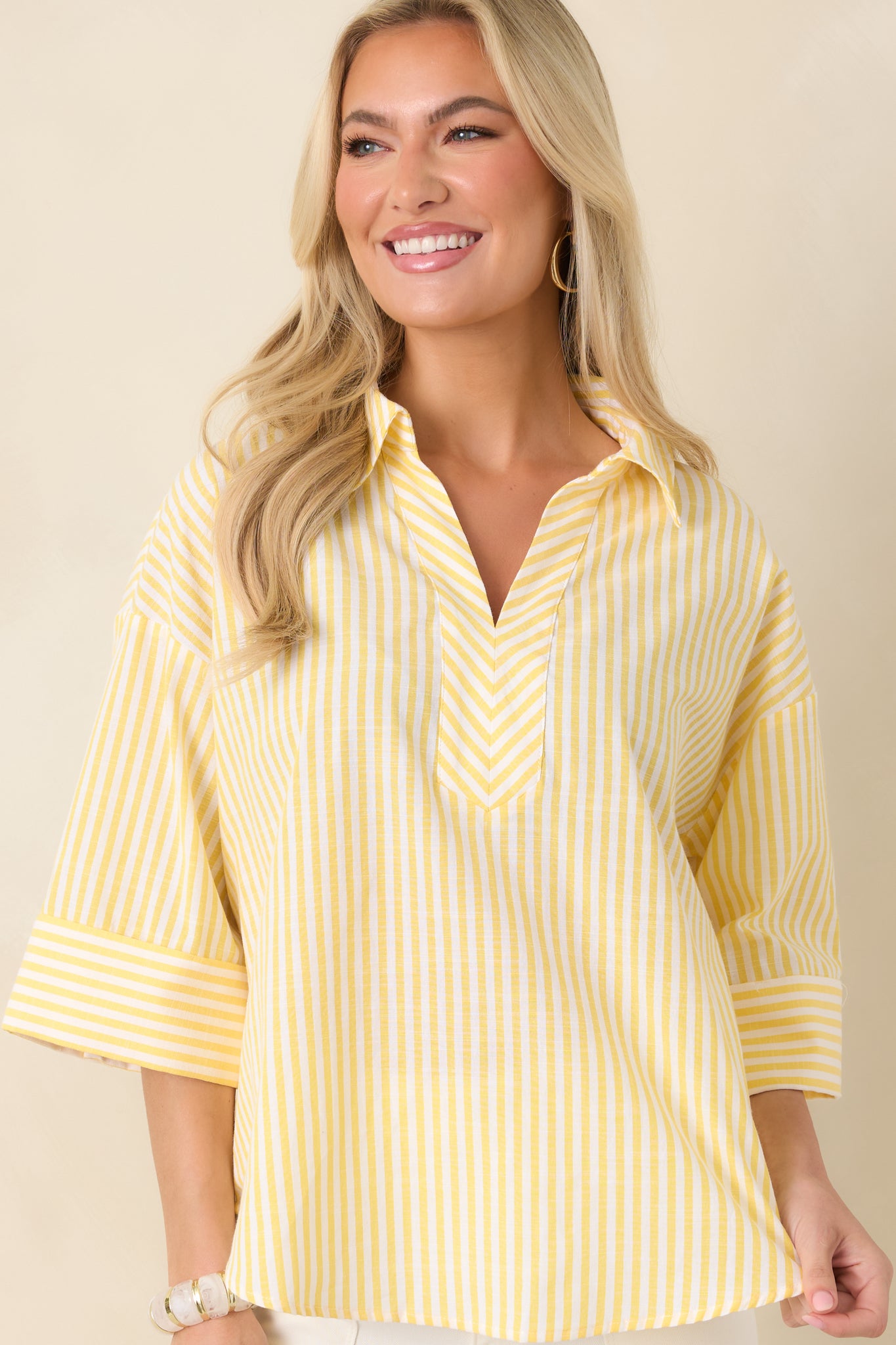 Cropped front view showing the curved hemline and relaxed construction of the striped blouse.