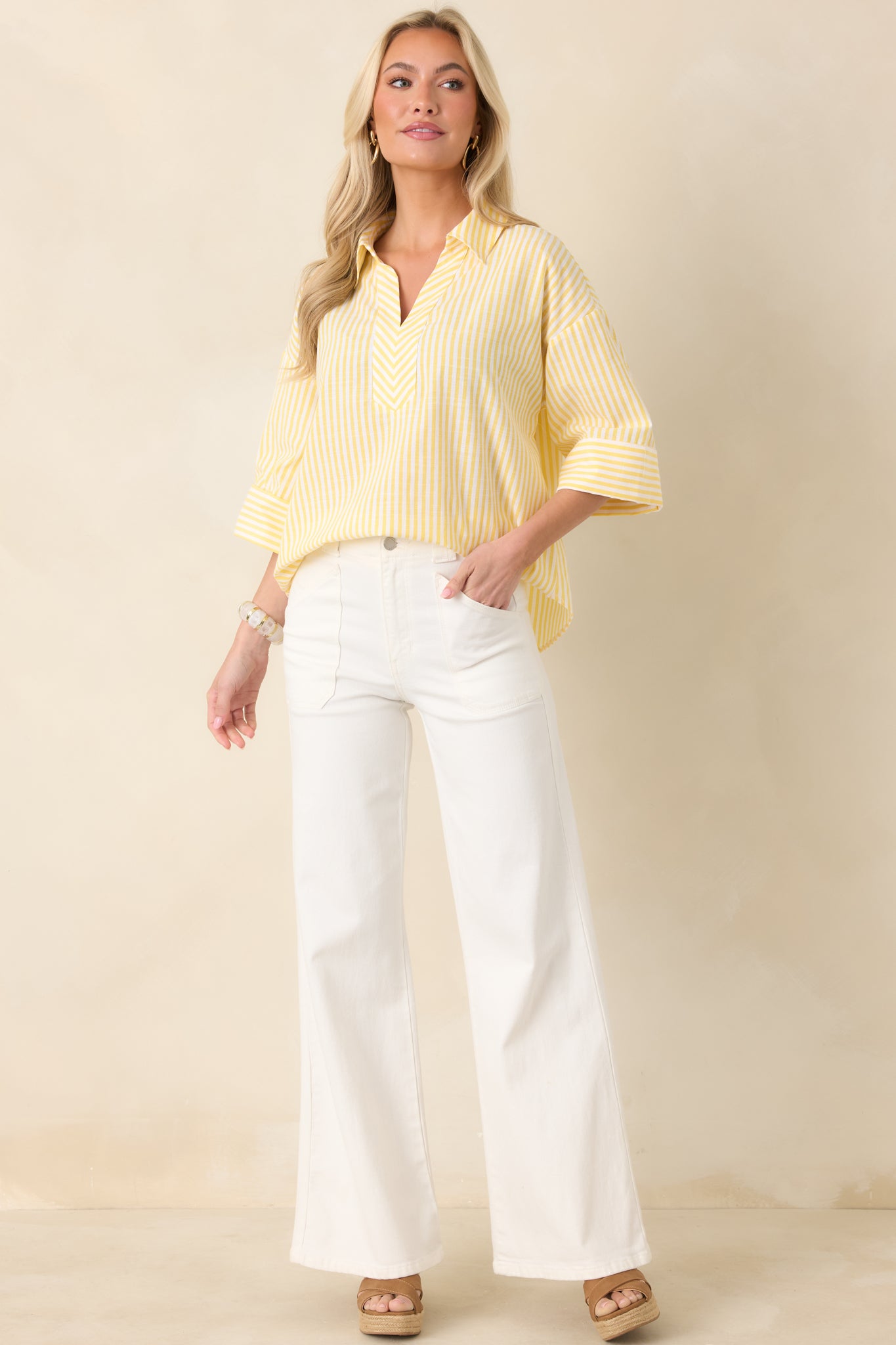 Full-body view of yellow and white vertical stripe blouse with a structured collar and split V-neckline.
