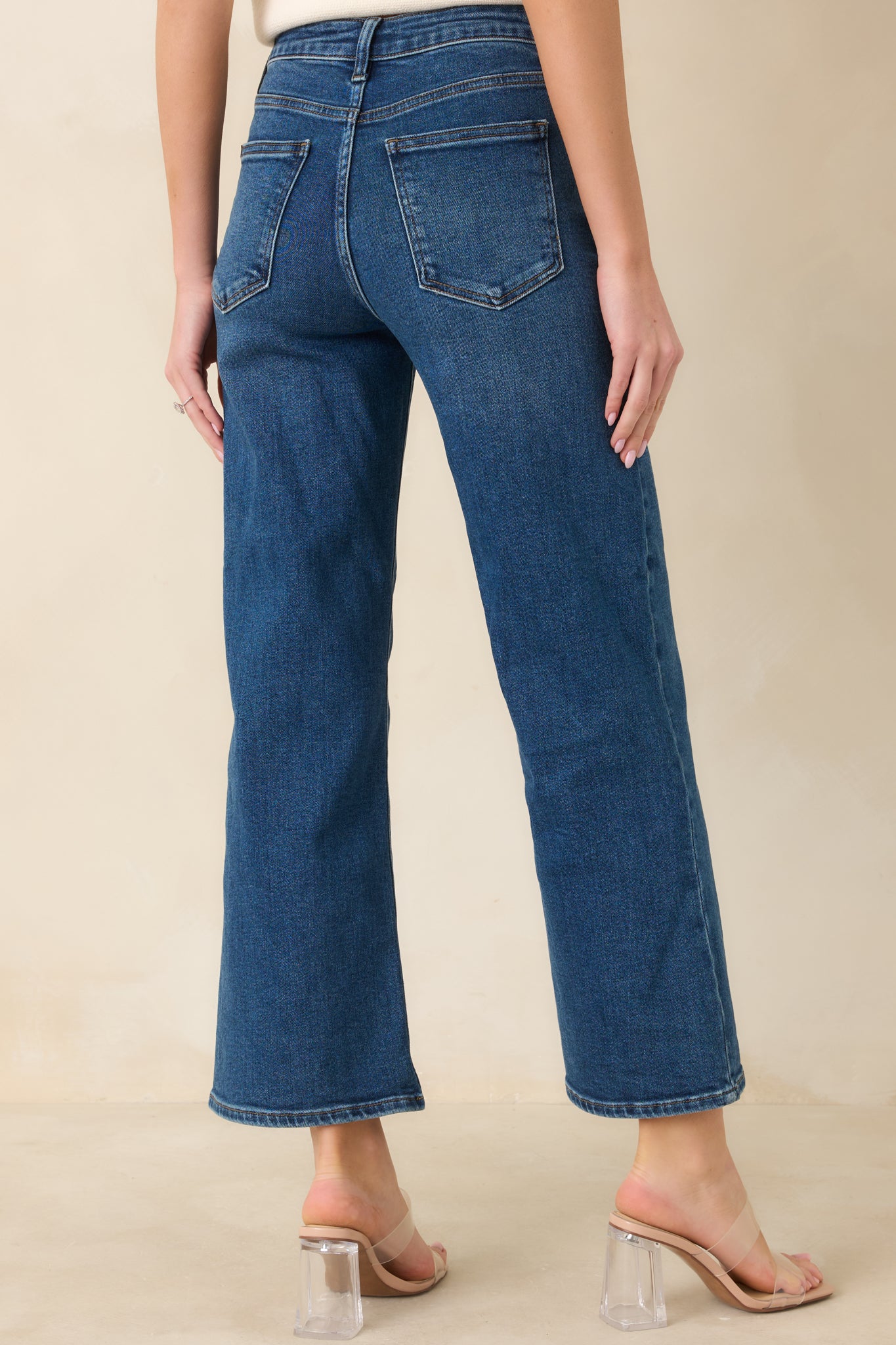 Back view of cropped dark wash jeans showing clean lines, belt loops, and back pocket details.