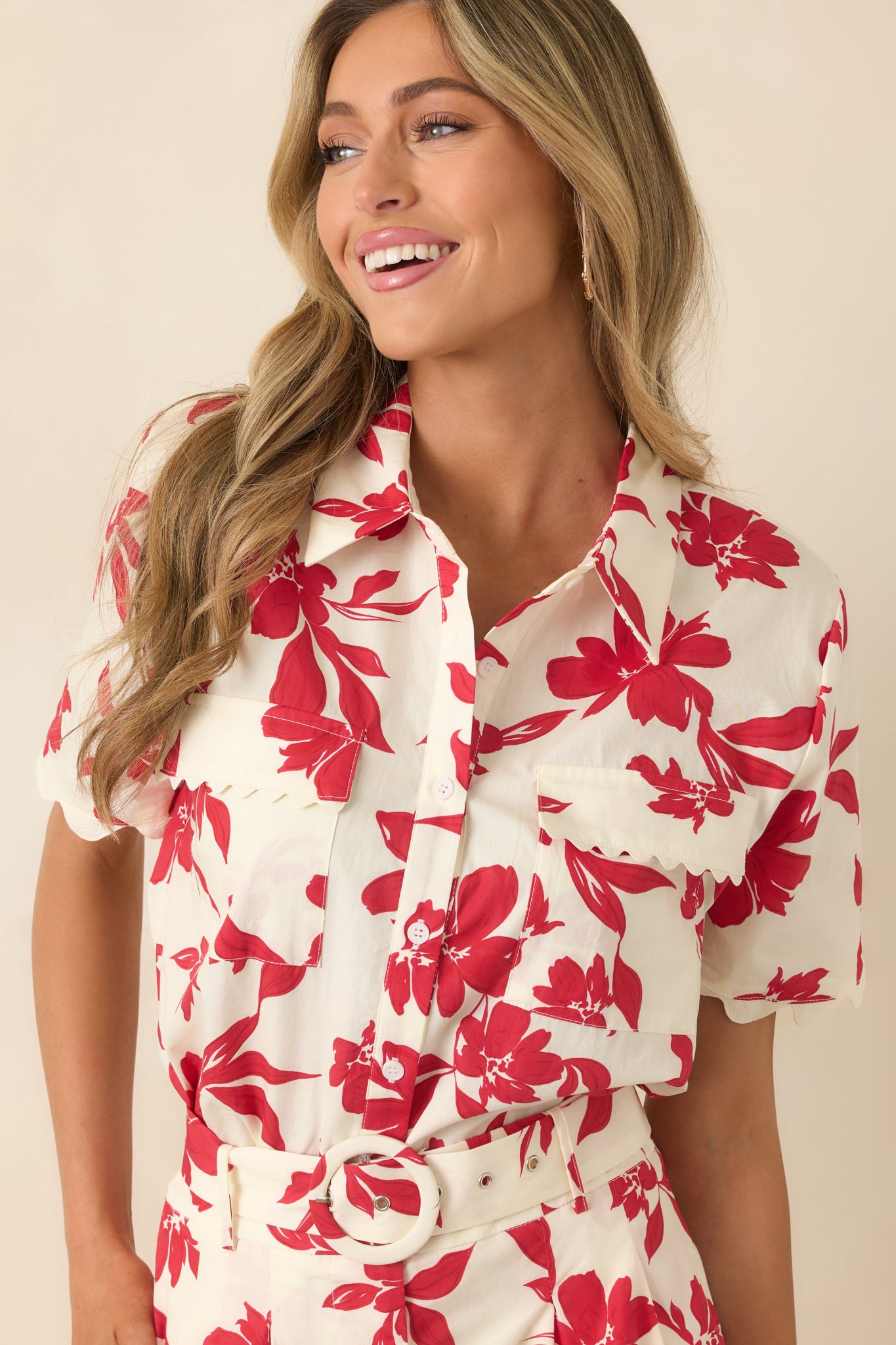Button-front floral top with scalloped pocket accents and short sleeves.