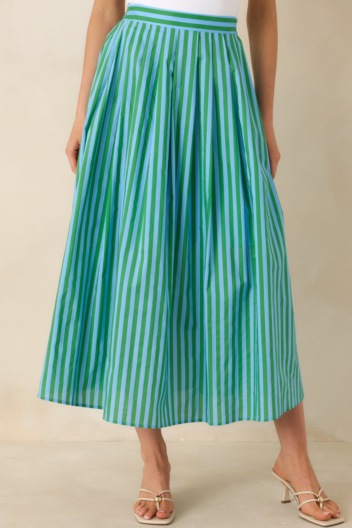 Detail of the skirt’s A-line shape with soft pleating and lengthening stripe pattern.