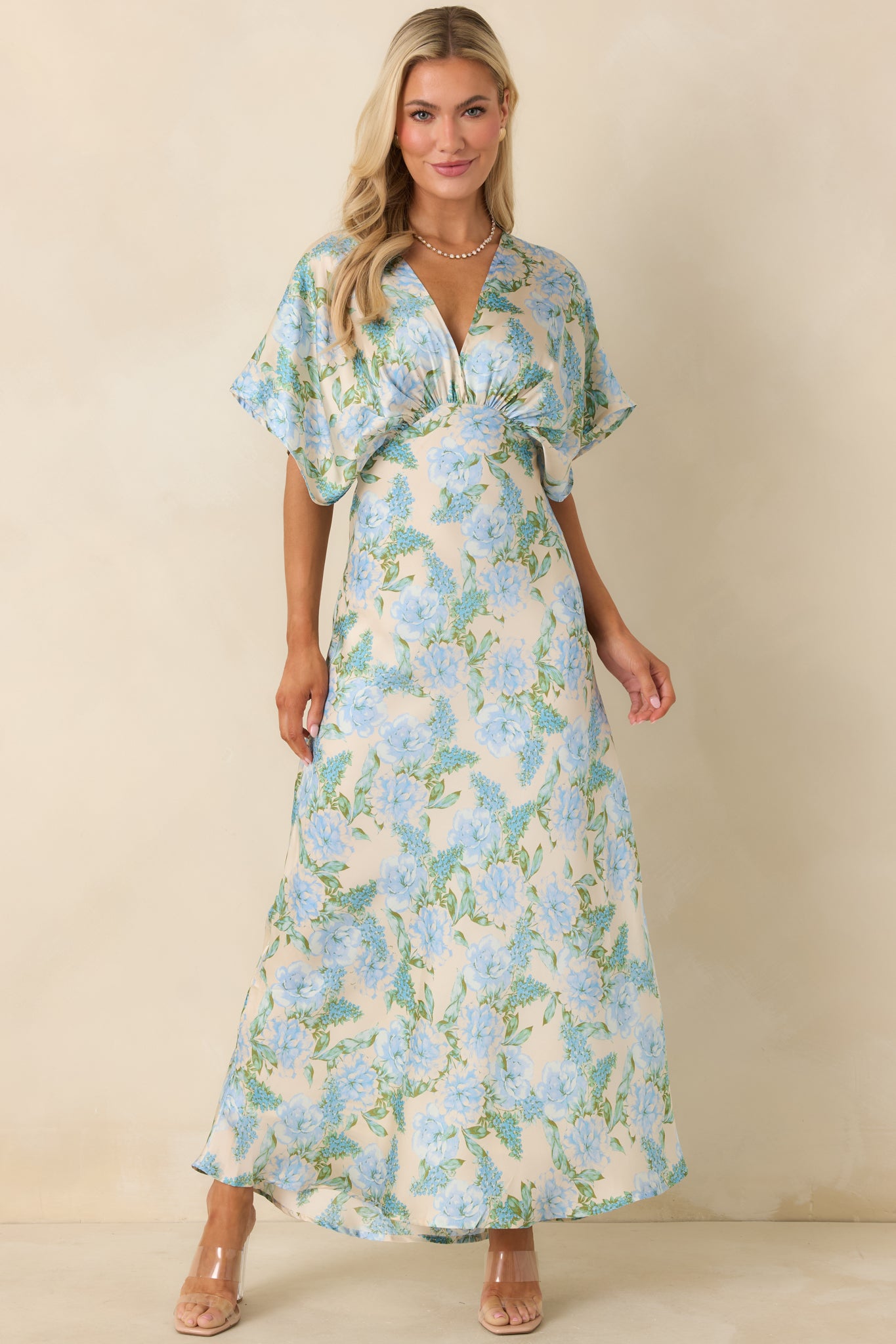 Full-length front angle showing the sky blue dress with a defined empire waist and airy movement.