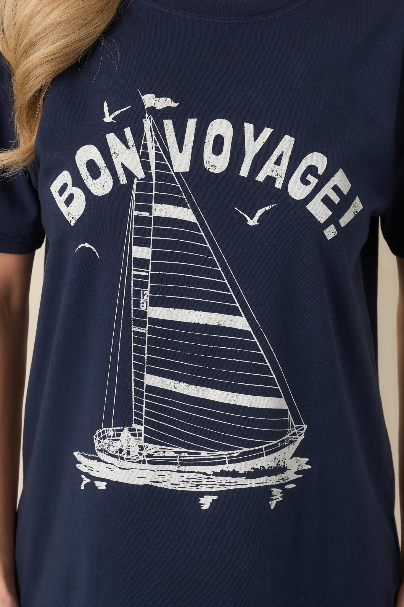 Close-up of navy knit fabric showcasing the crew neckline, short sleeve stitching, and fine, smooth texture.