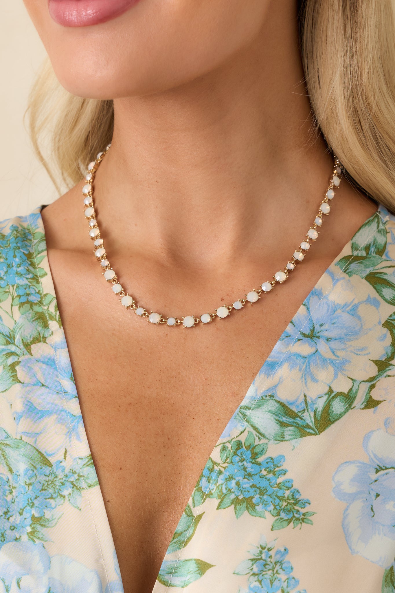 Cropped view of gold-tone necklace highlighting bezel-set opal stones and delicate chain.