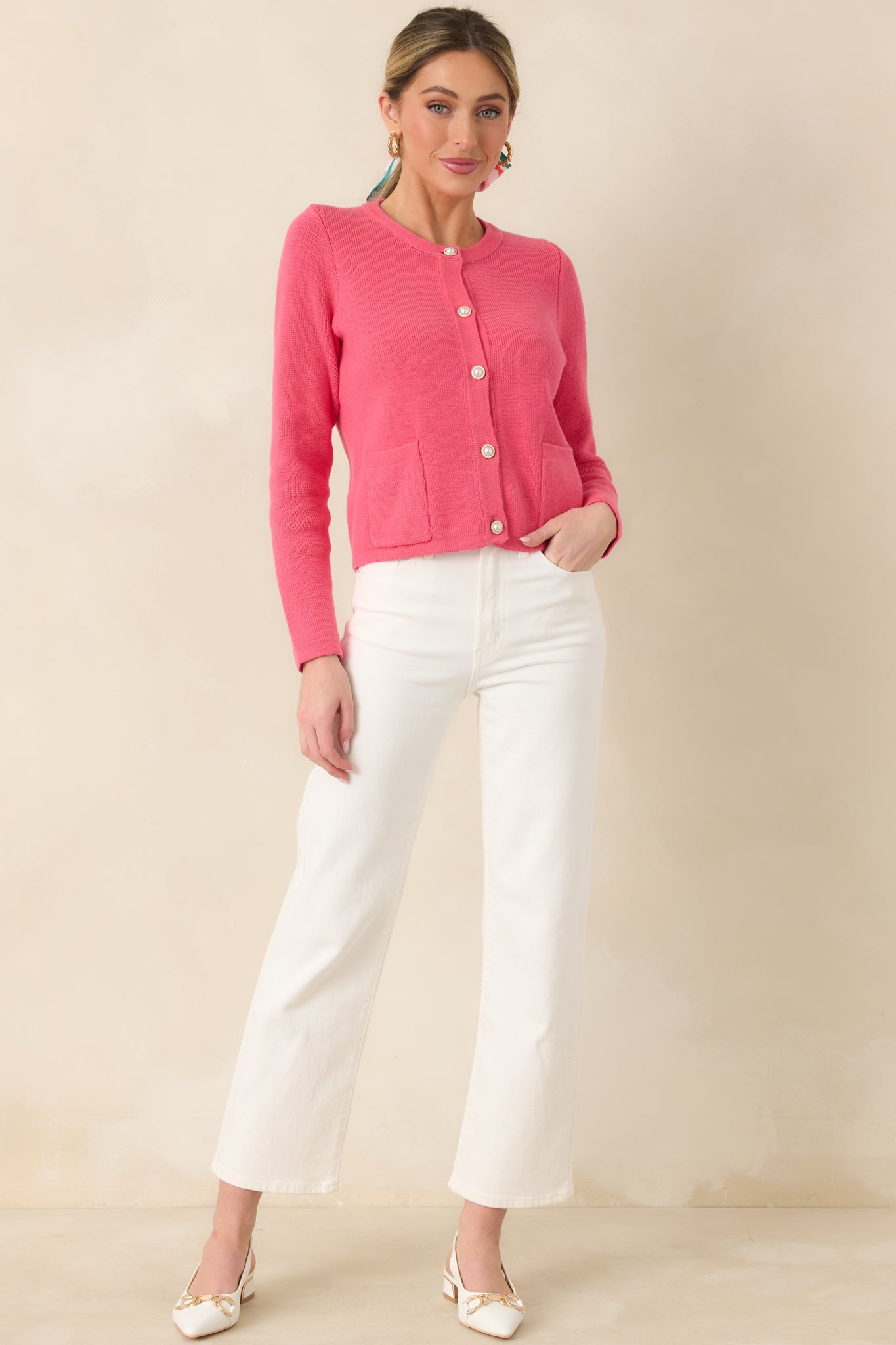 Soft cotton cardigan with a subtly textured knit, round neckline, pearl-inspired buttons along the front, and two neatly placed patch pockets.