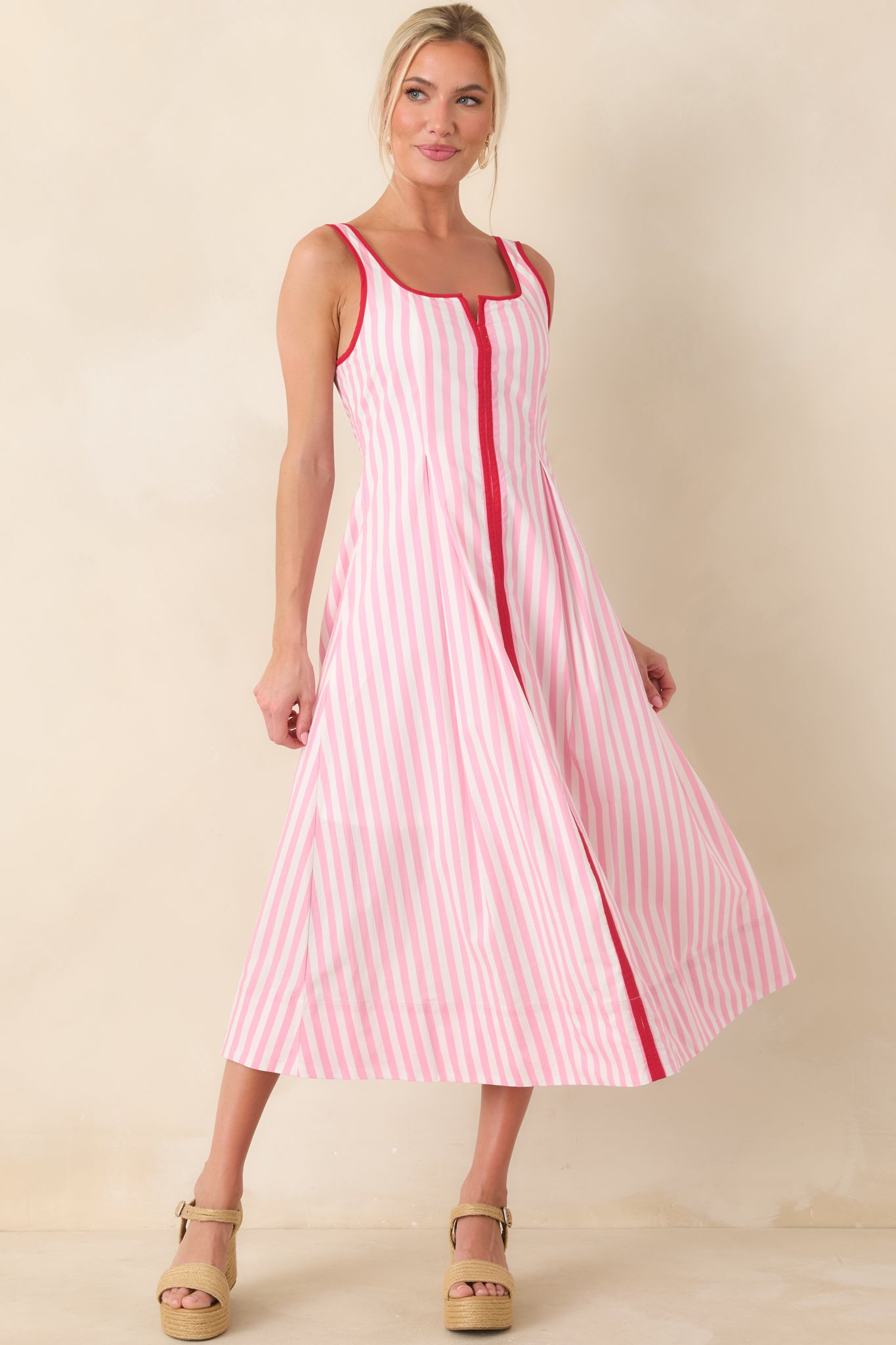 Pink and white striped midi dress with fitted bodice, vertical stripes, and flowy skirt.