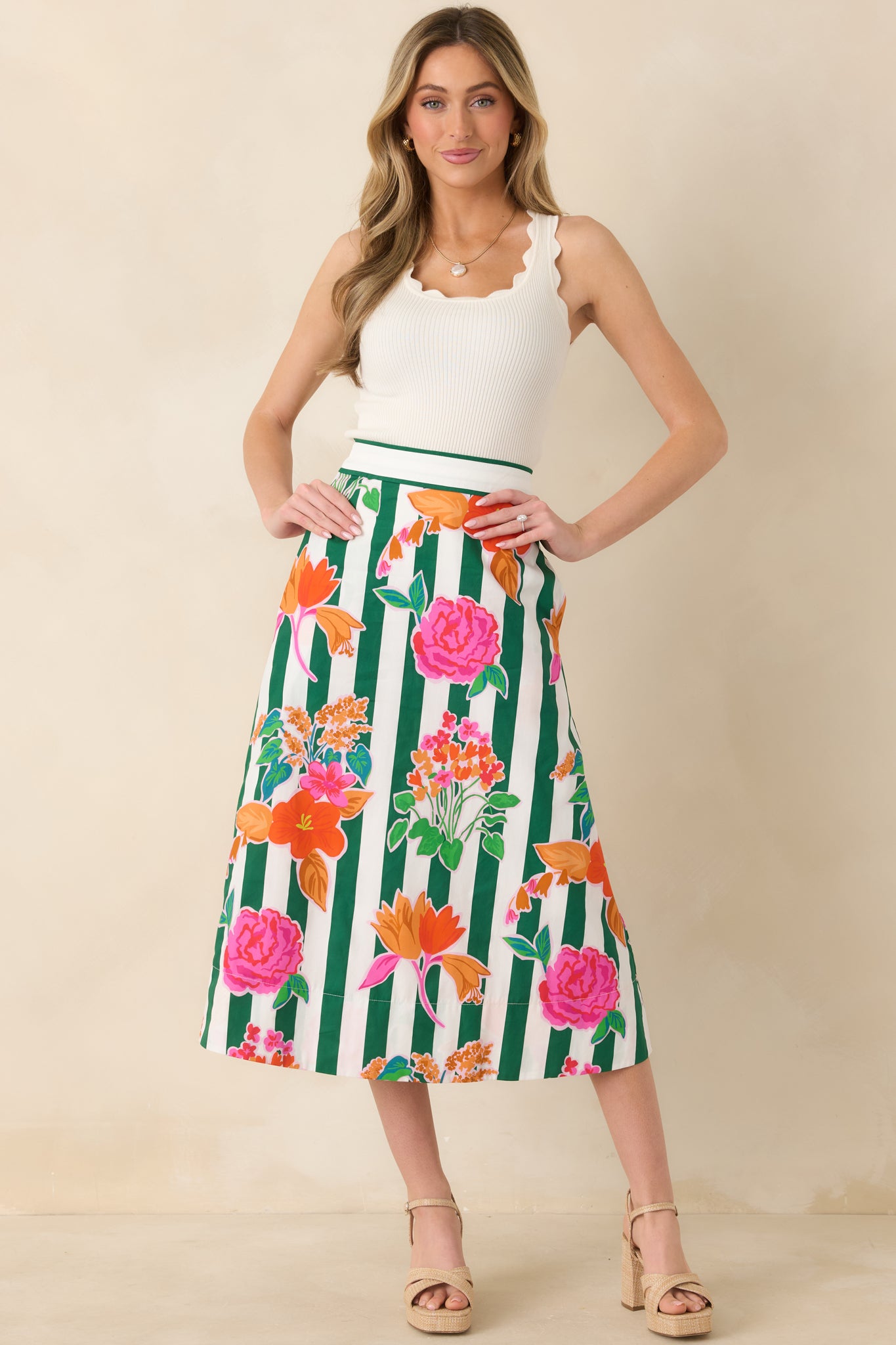 Midi skirt featuring vibrant floral blooms layered over crisp green vertical stripes, high waist, and a structured cotton construction for an elegant flow.