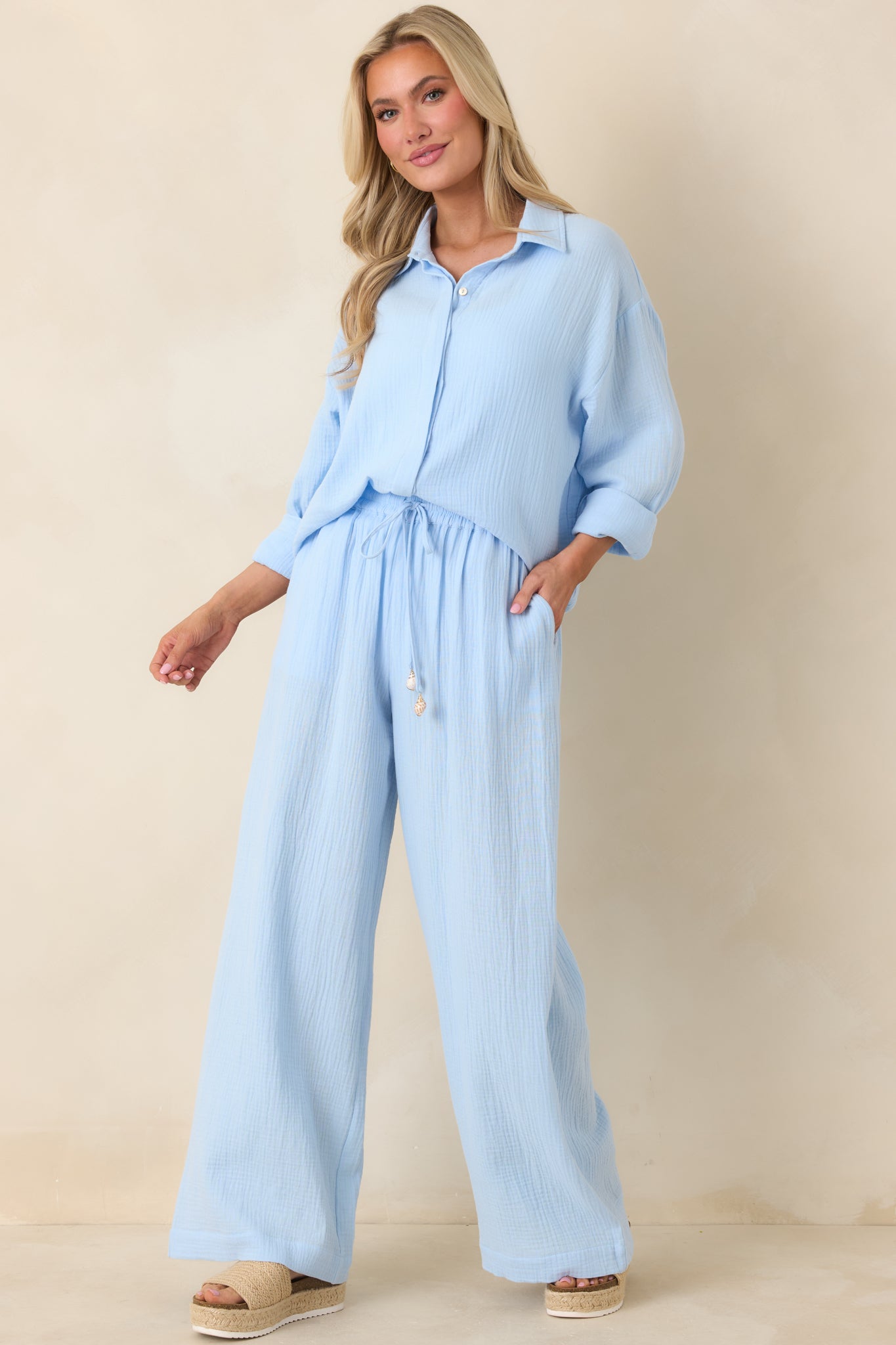 Blue cotton pants with relaxed wide-leg silhouette, elastic waistband, and full-length drape.