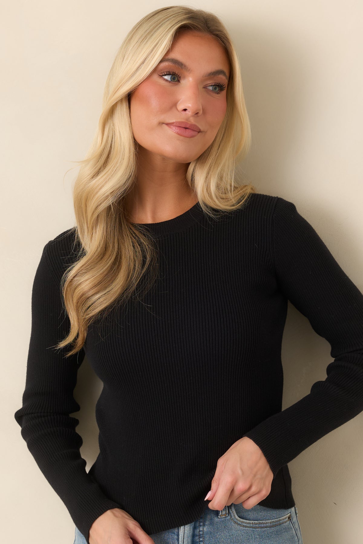 The black ribbed top features a rounded crew neckline and a smooth, fitted bodice.