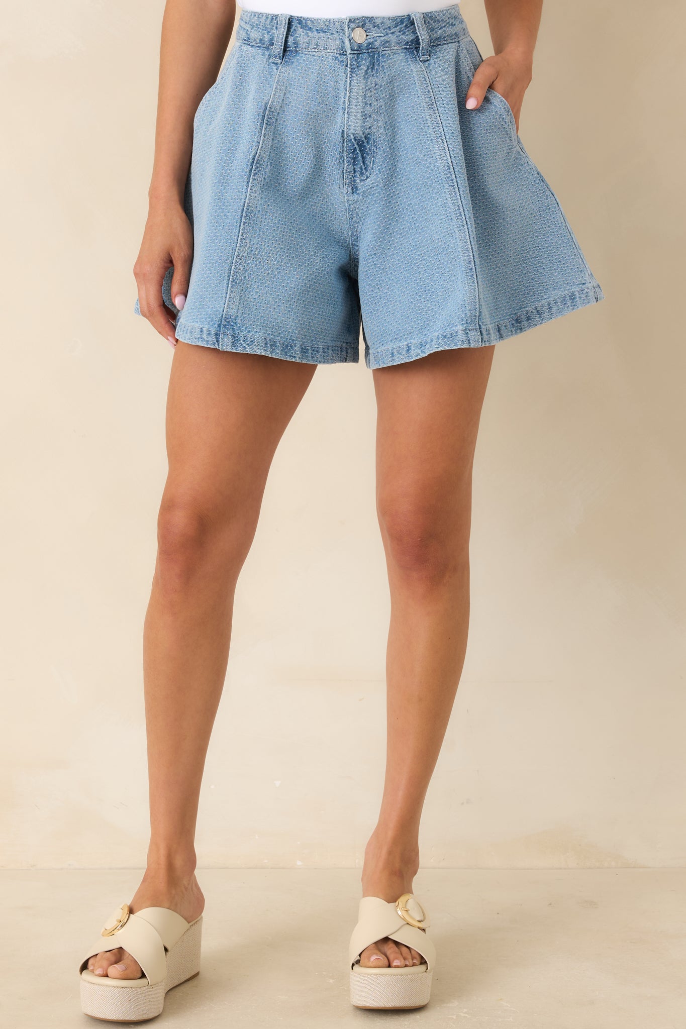 Textured denim fabric with high-rise waistband and belt loop detail.