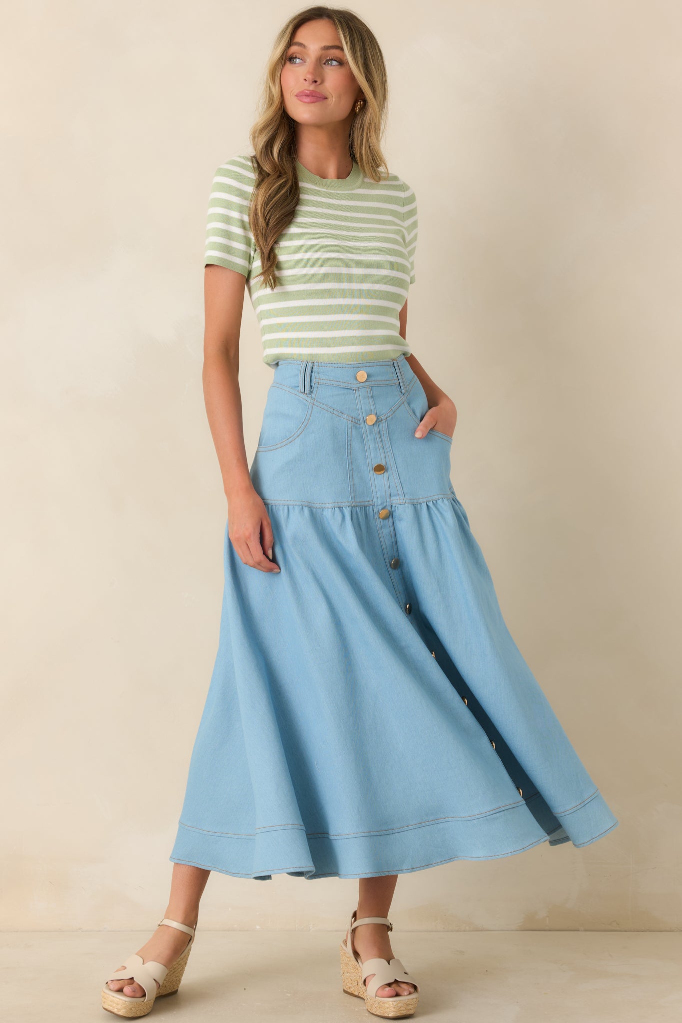 Light wash denim maxi skirt with high-rise waistband and gold button-down front.