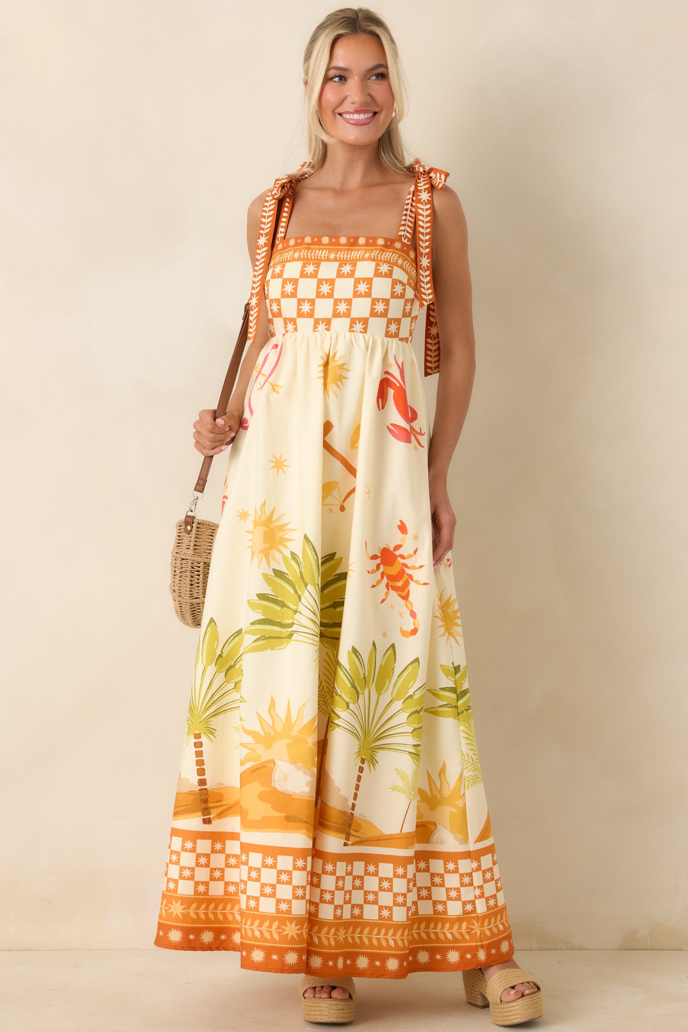 Ivory maxi dress with adjustable tie straps, fitted bodice, and flowy skirt.