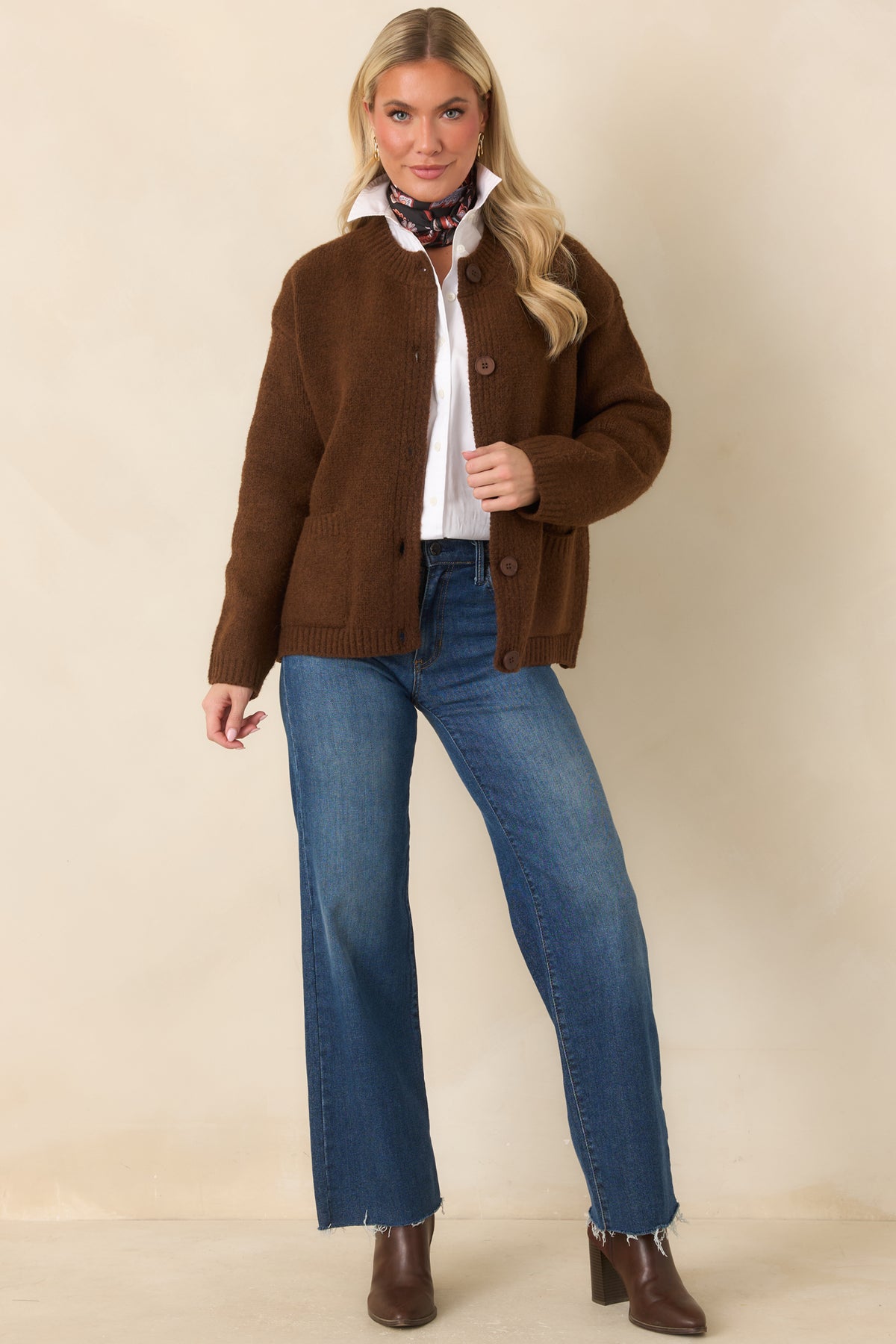 The textured brown cardigan features a relaxed silhouette, dropped shoulders, and long sleeves with ribbed cuffs.