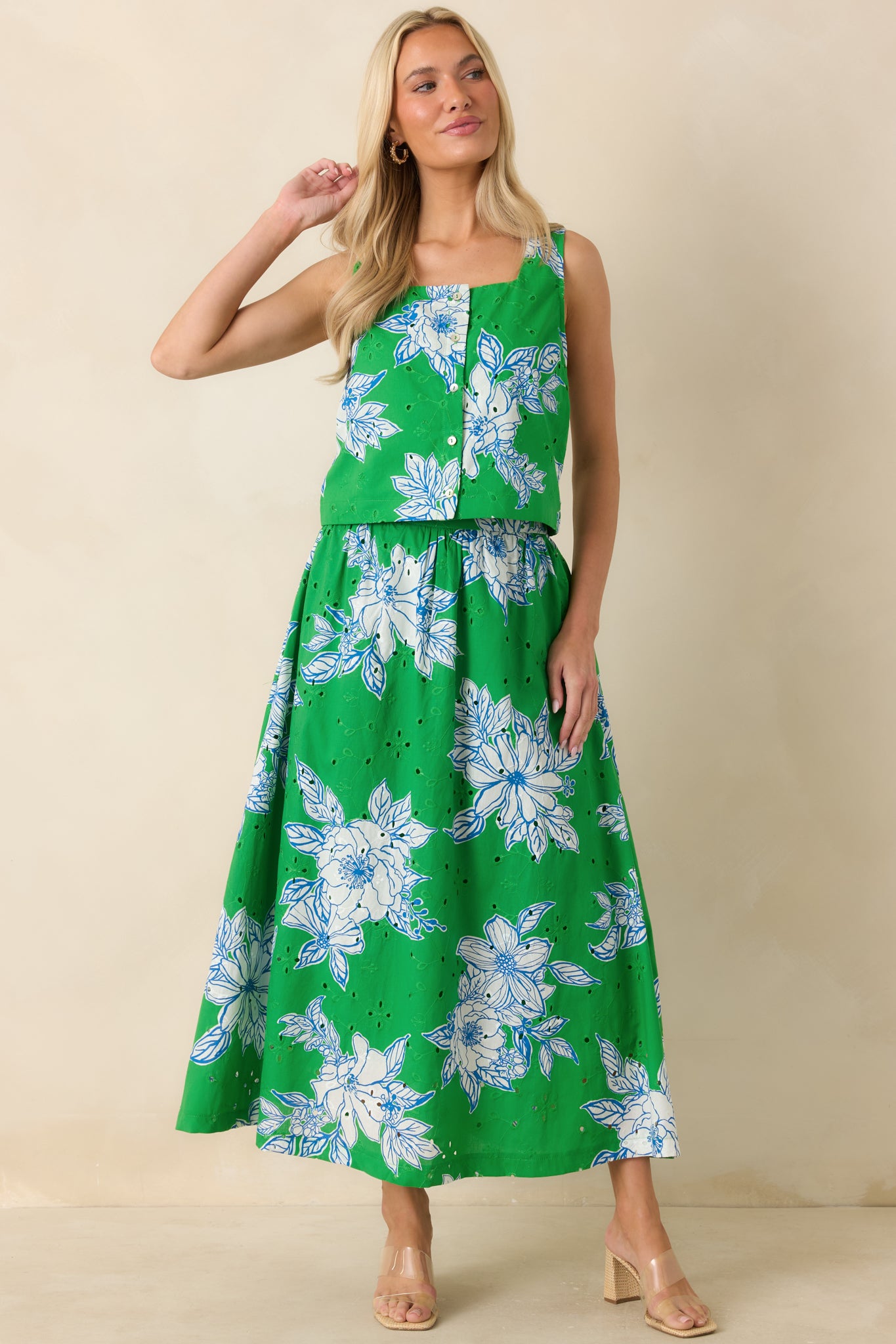 Green and white floral midi skirt featuring a lightweight cotton eyelet fabric, flowing silhouette, and elasticized waistband for an easy fit.