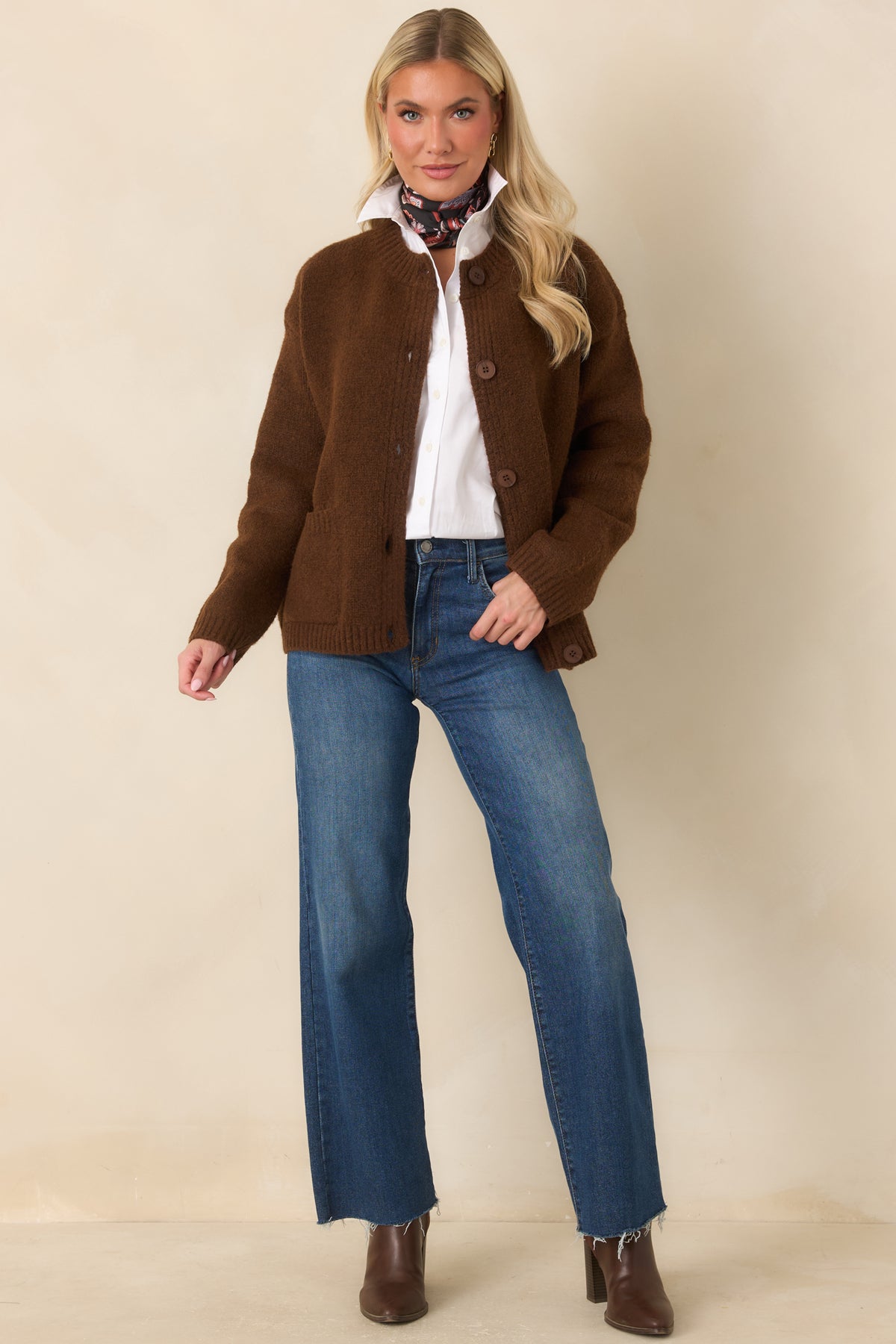 A ribbed crew neckline, tonal buttons, and matching ribbed hem complete the cozy silhouette of this brown knit cardigan.