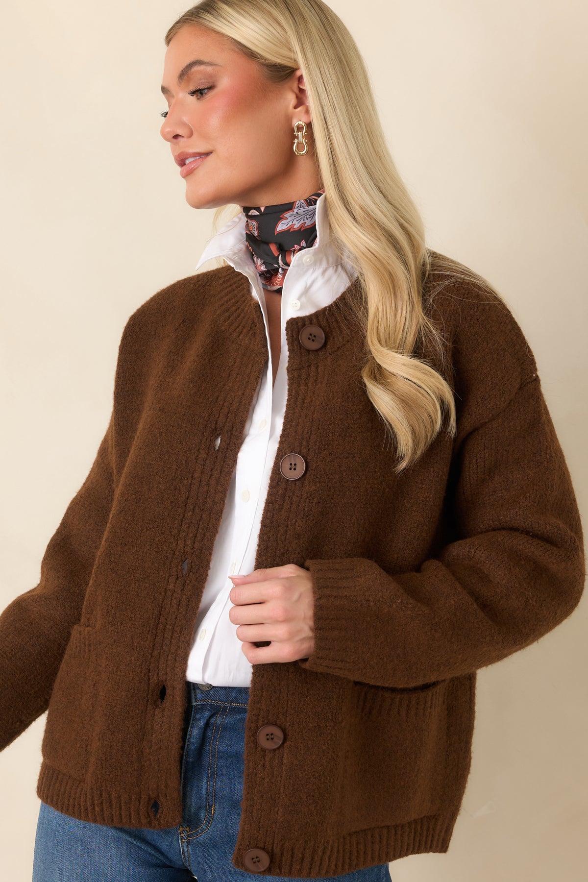 The chestnut brown cardigan features tonal buttons and a softly textured knit across the relaxed front bodice.