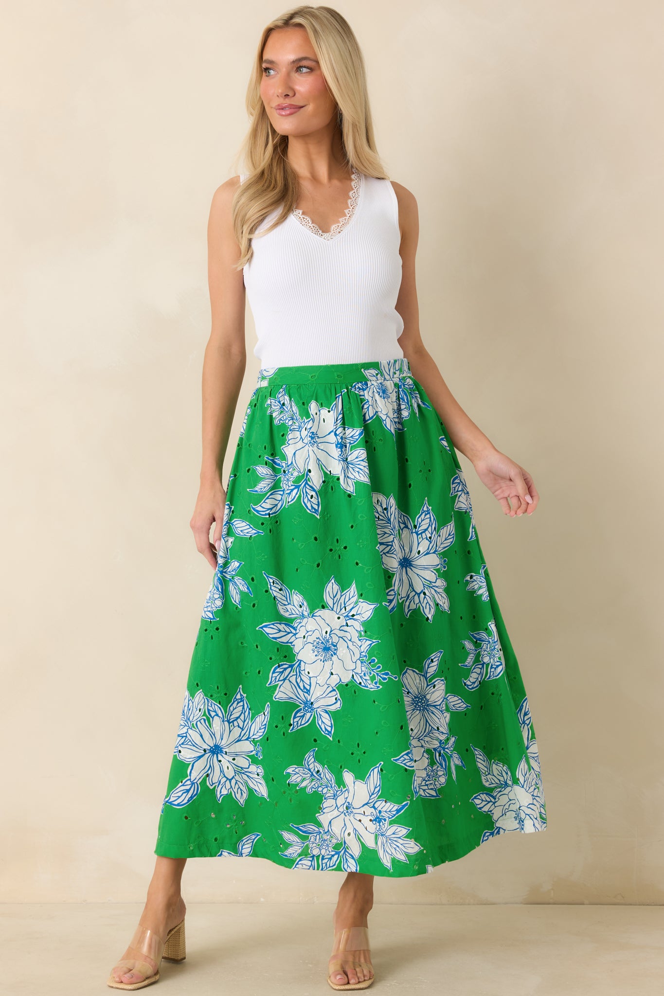 Floral eyelet midi skirt showcasing a soft drape, side pockets, and a breezy cotton construction in a fresh green and white pattern.