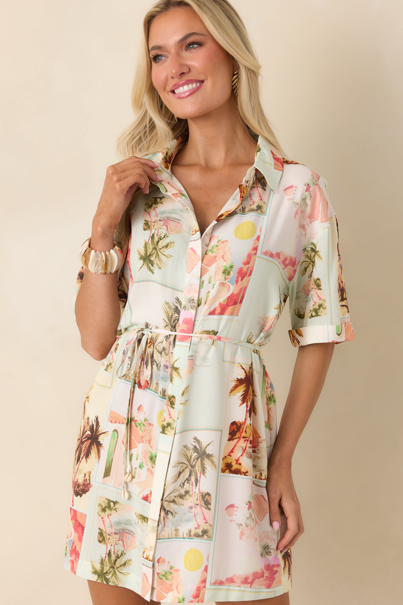 Close cropped look at the button-front detail and collared neckline on a multi-print mini shirtdress