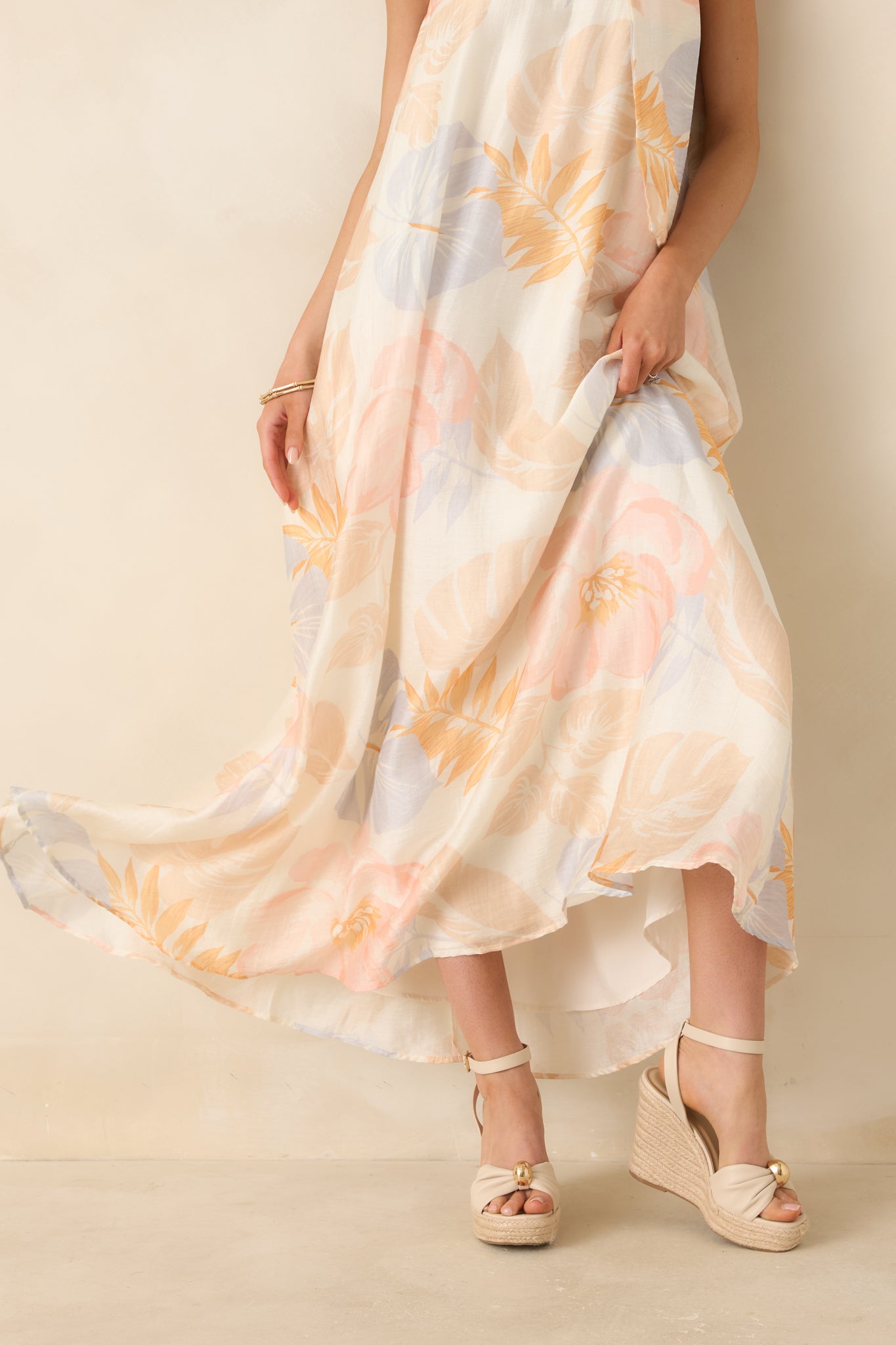 Close-up of bottom hem showing soft drape, gentle shimmer, and fabric texture of the ivory maxi dress.