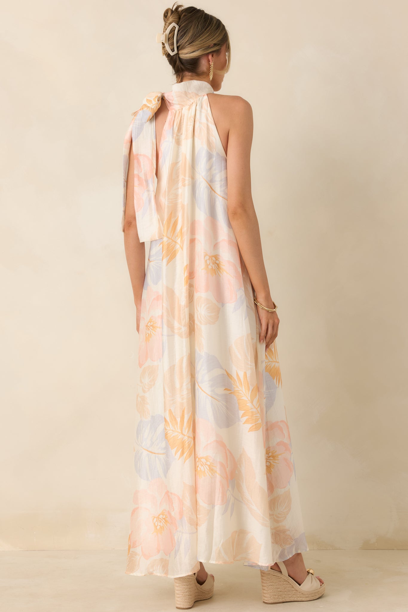 Rear view of ivory maxi dress with adjustable halter tie and full-length flowing skirt.