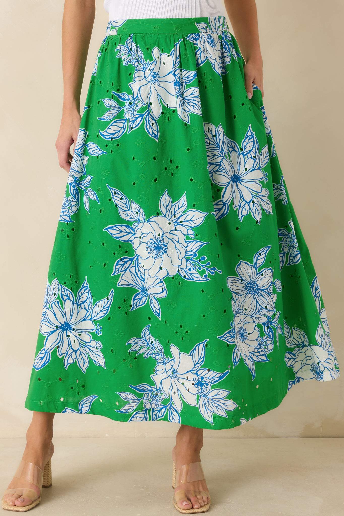 Detailed focus on the green and white floral pattern layered across the cotton eyelet fabric.