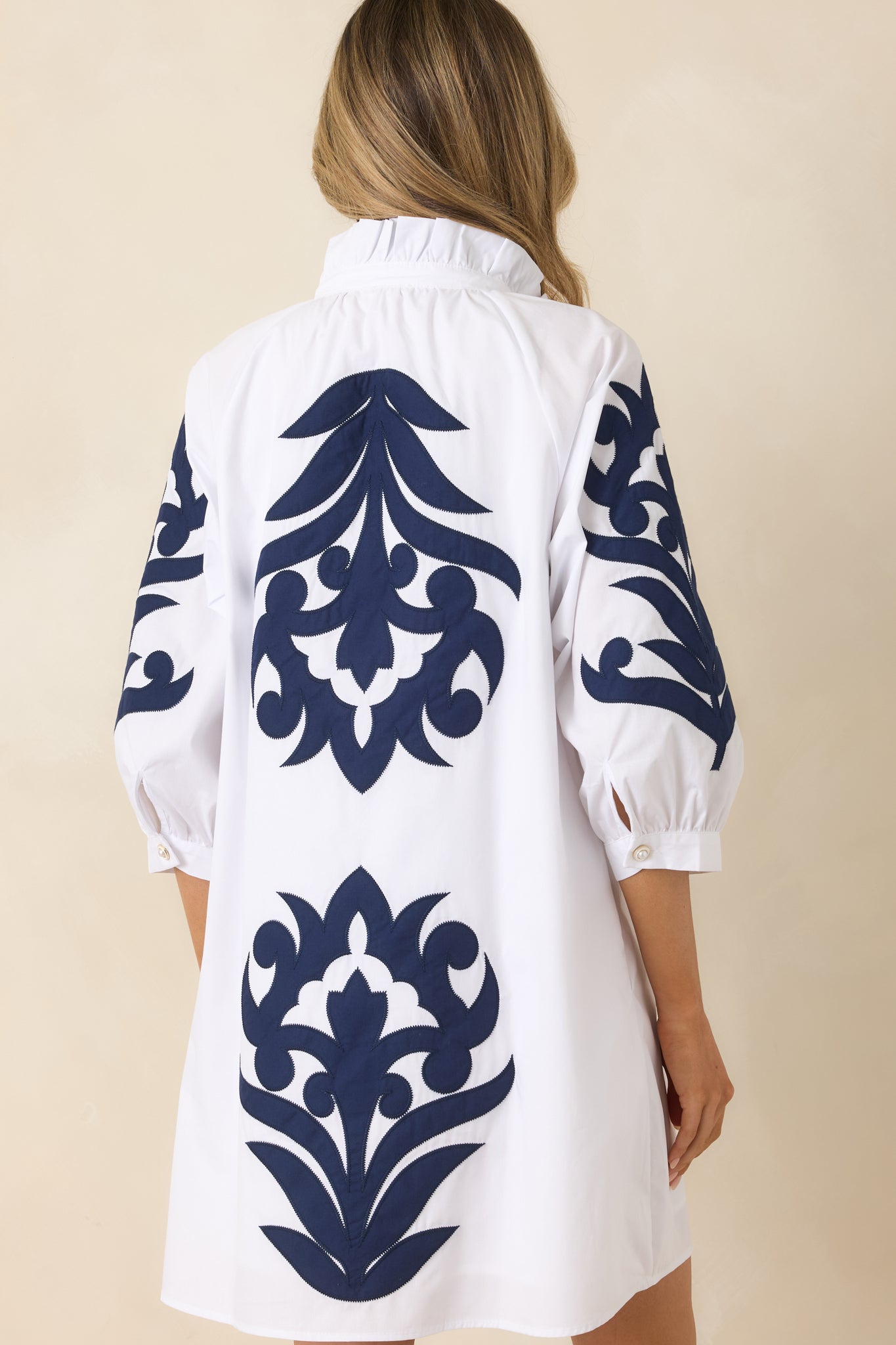 Rear view of white mini dress with navy detailing and relaxed fit.