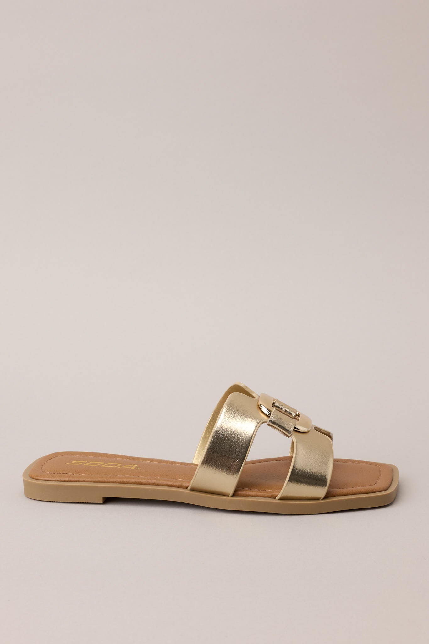 Side profile of the gold sandal showing the structured square toe and wide upper strap.