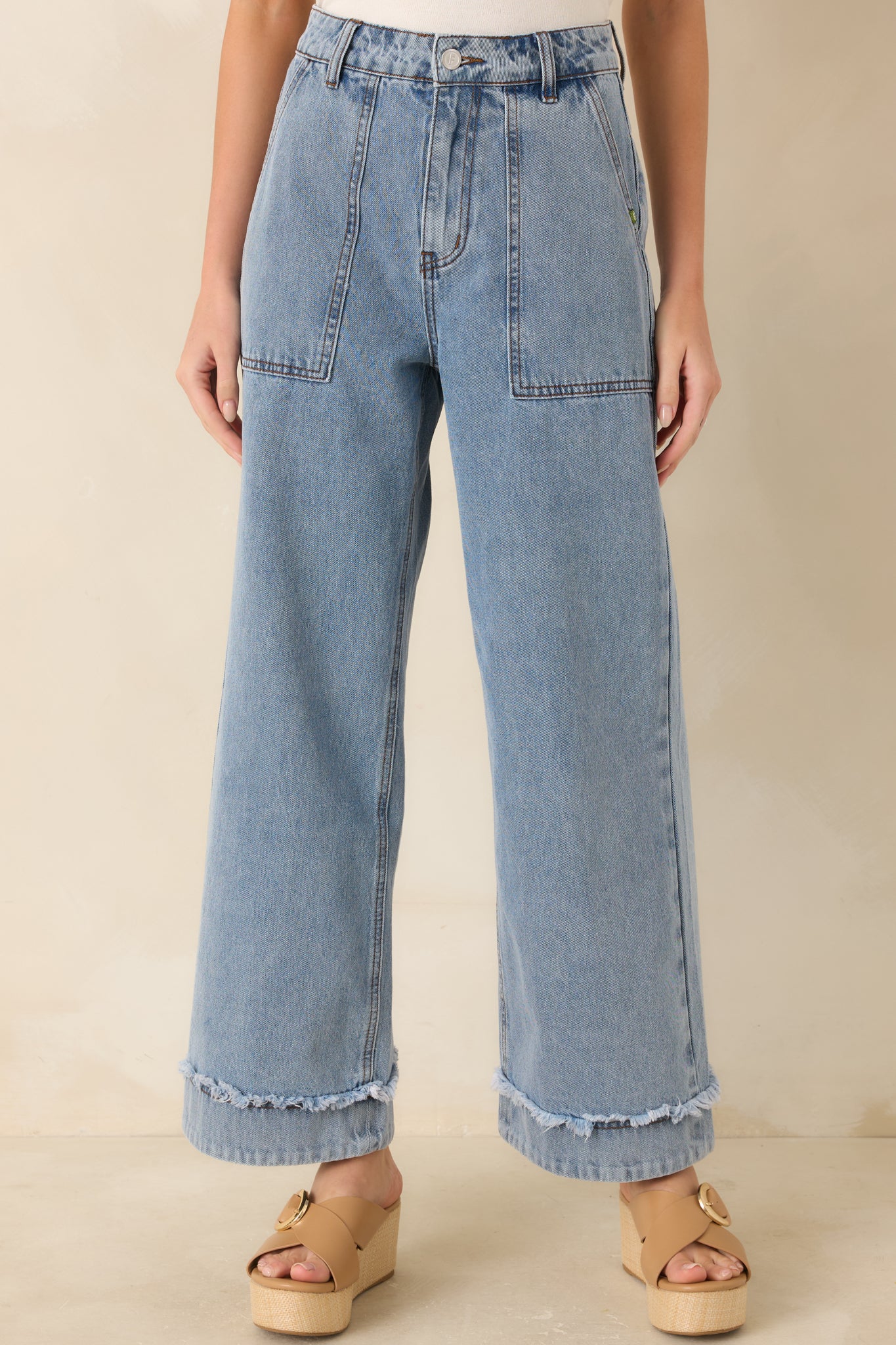 Light wash jeans, highlighting the high-rise waist and utility-style front patch pockets.