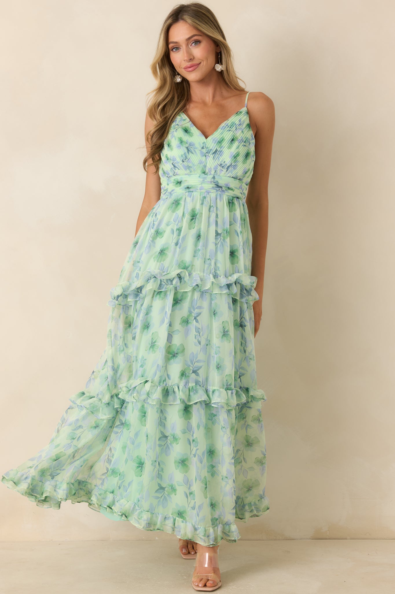 Green maxi dress featuring a floral chiffon overlay, pleated surplice V-neckline, and adjustable spaghetti straps.