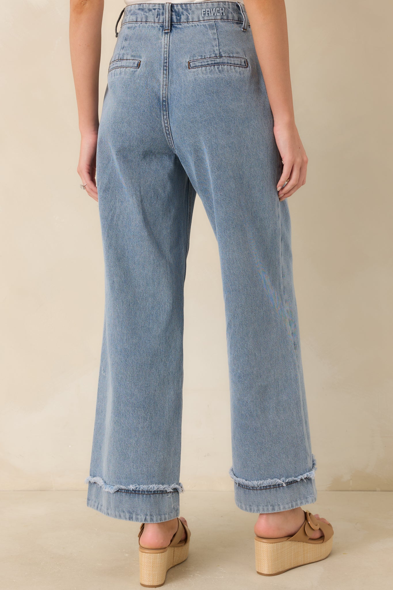 Rear view of the light wash jeans, showing the high-rise fit and relaxed wide leg silhouette.