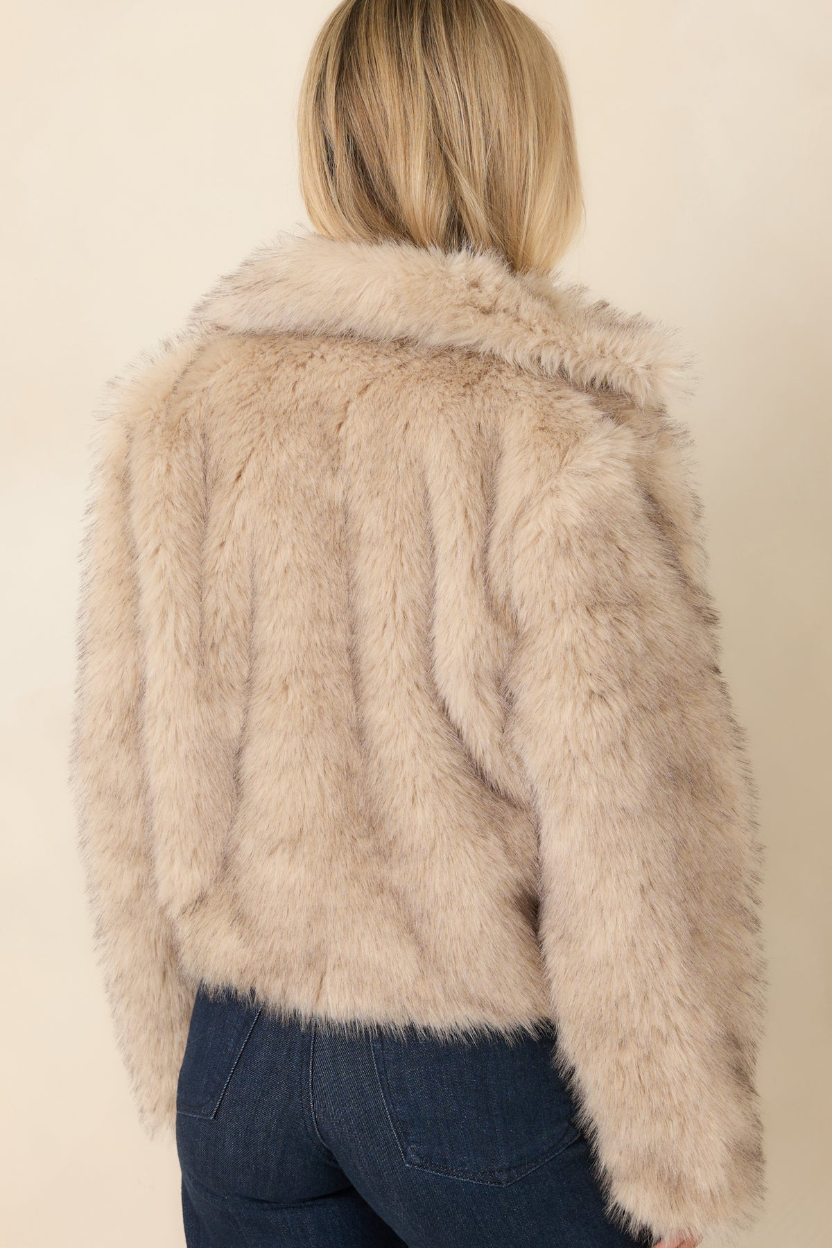 Back view of Beige faux fur jacket highlighting the oversized shawl collar and dense, fluffy long-pile texture.