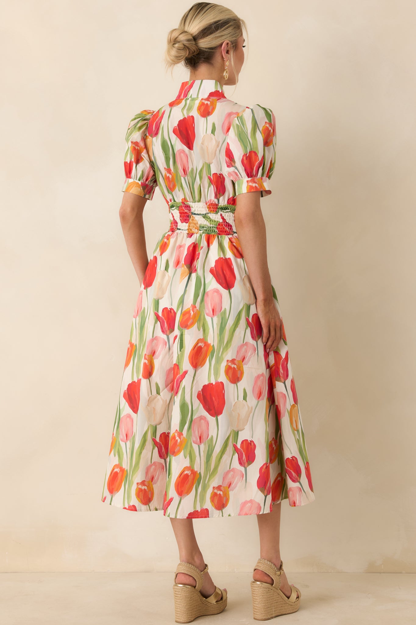 Rear view of ivory midi dress with tulip print, puff sleeves, smocked waist, and full skirt silhouette.