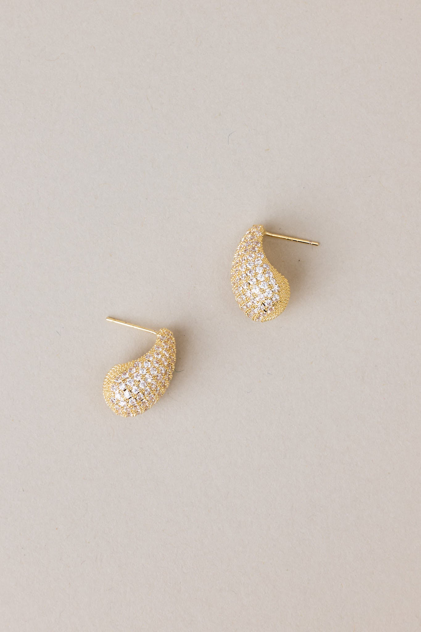 Tear shaped yellow gold earring with mini rhinestones covering it, and gold hardware.