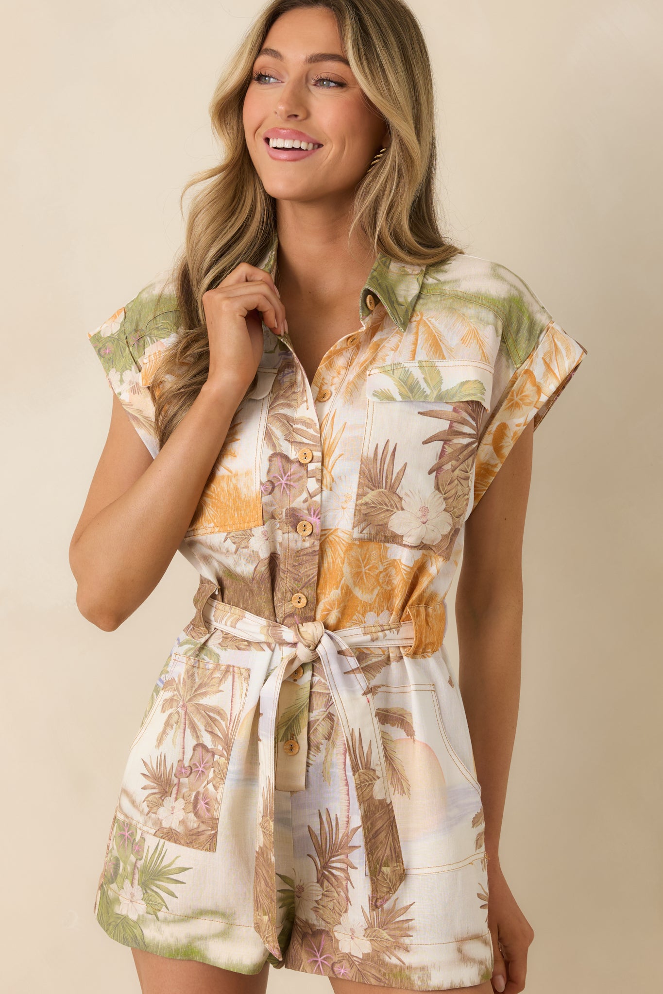 Cropped view highlighting collared neckline and button front on tropical romper.