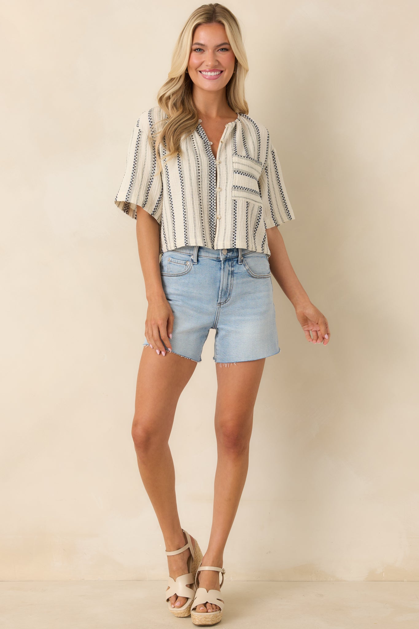 Cropped striped top with button closure, round neck, and structured everyday silhouette.