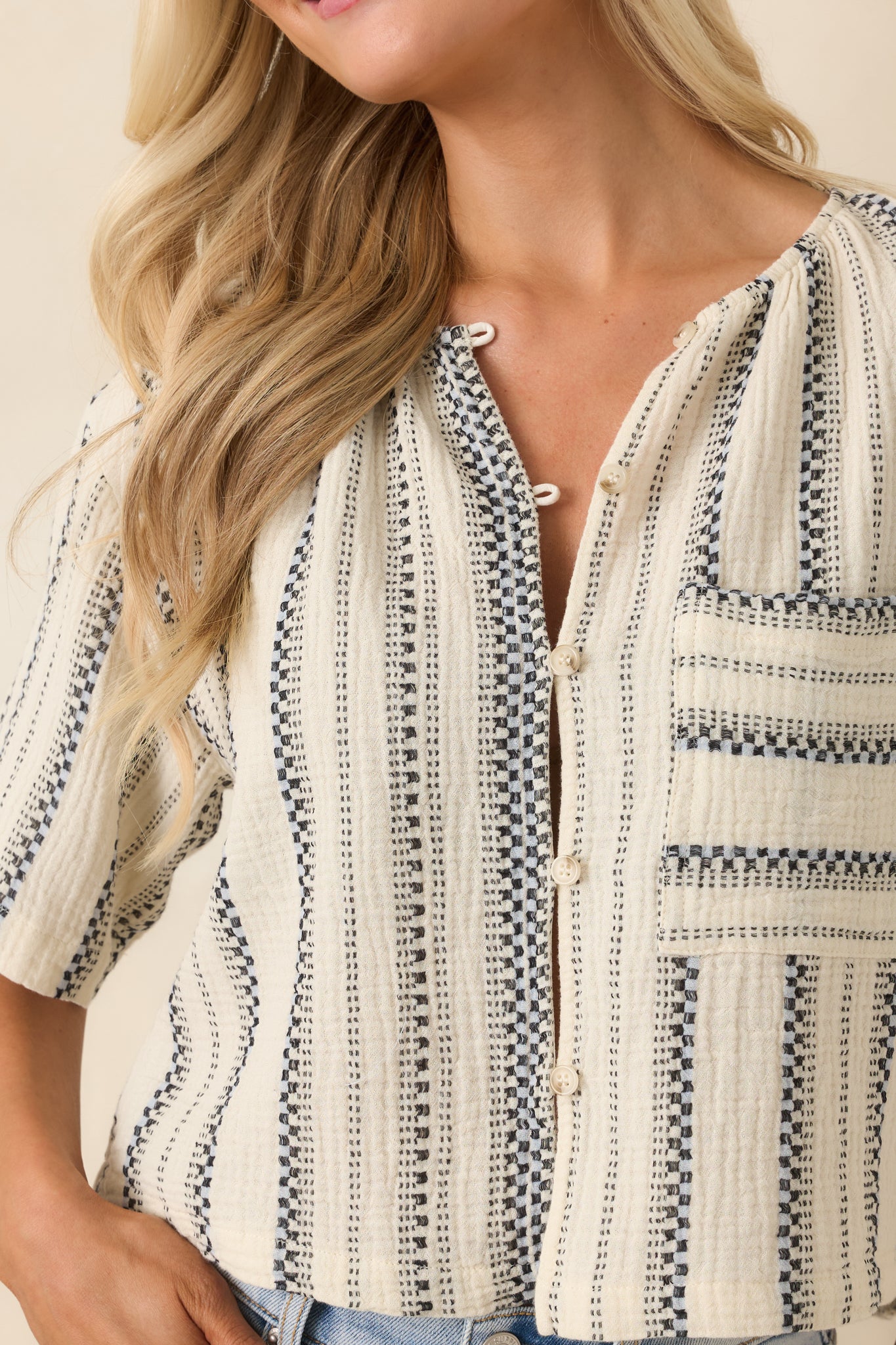 Ivory and black woven stripe fabric with button placket and soft cotton texture.