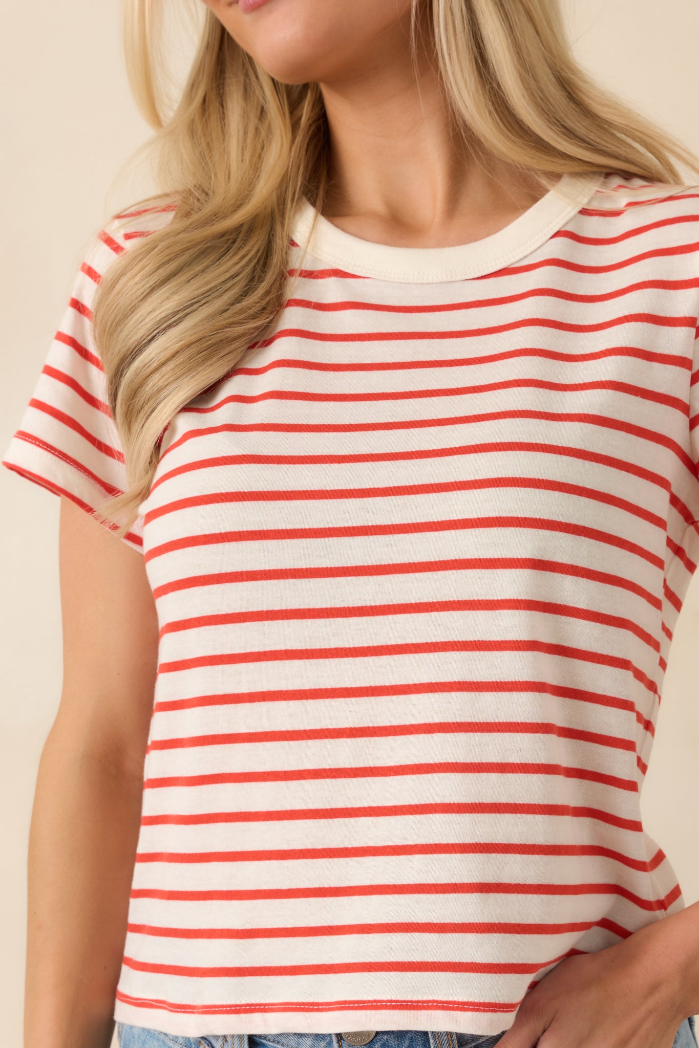 Close-up of the cotton fabric showing the poppy red and white stripe pattern and soft woven texture.