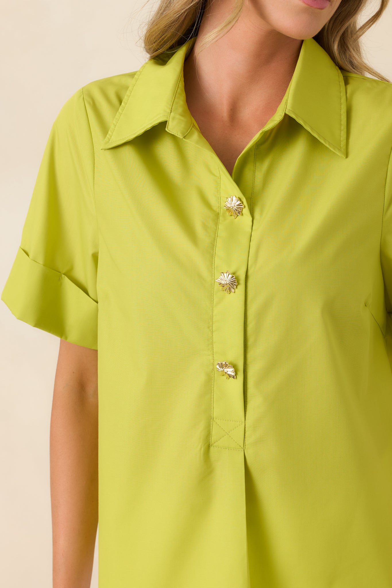 Detailed image highlighting the statement buttons, collar structure, and lightweight woven texture with subtle back pleat detailing.