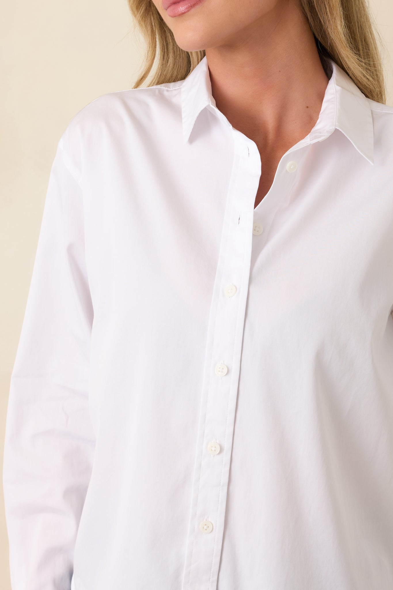 Detailed look at white cotton poplin fabric with front button closure and classic collar.