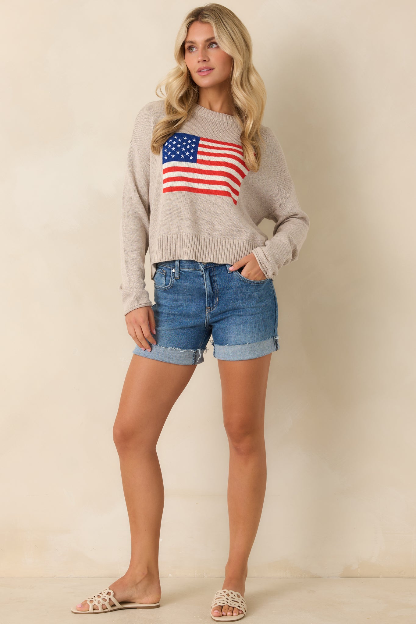Natural heather knit sweater with American flag graphic, relaxed fit, and classic crew neckline.