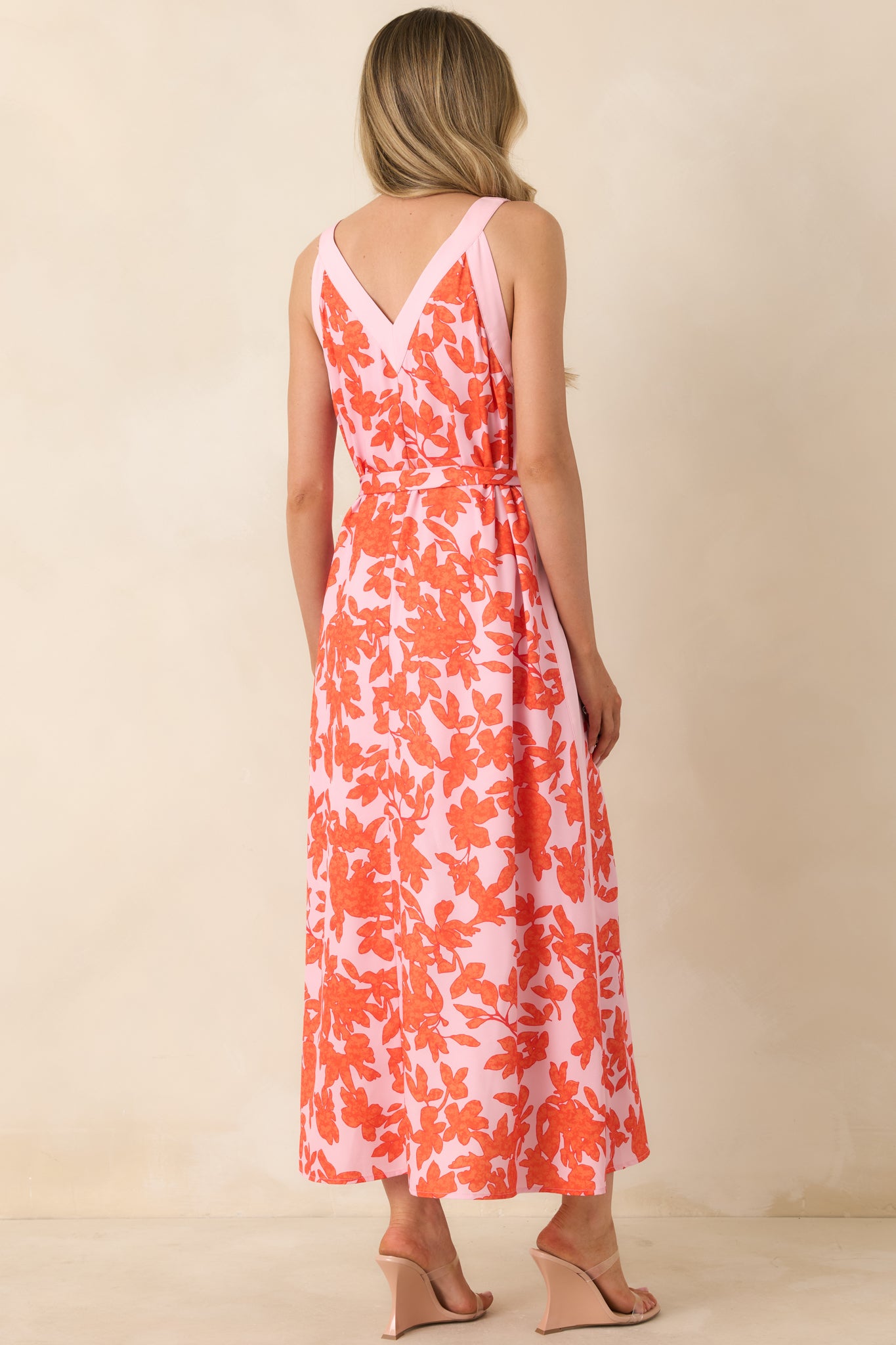 Rear view of dress with V-back, coordinating tie belt, and flowing floral skirt.