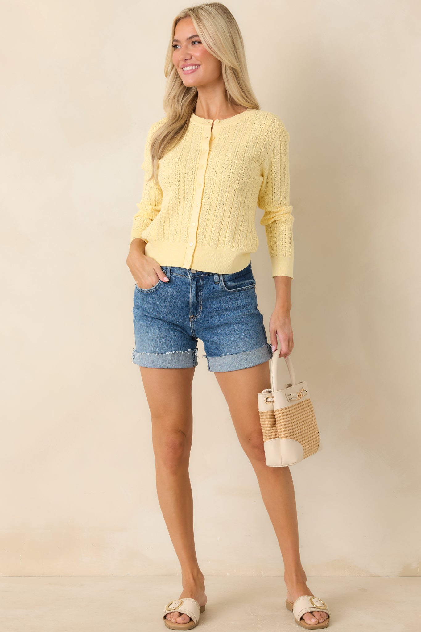 Lightweight eyelet cardigan featuring crew neckline and soft cropped silhouette.