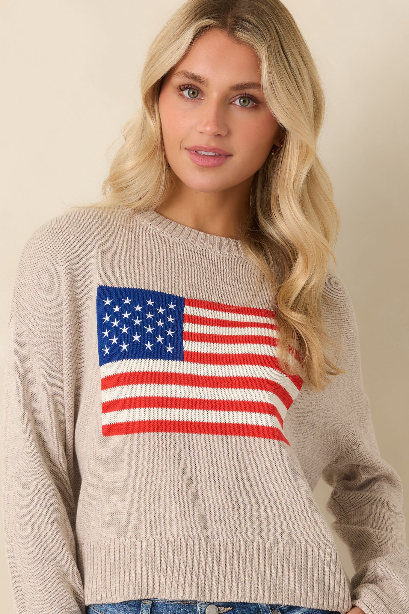 Long sleeve heather sweater with classic ribbed trim and woven American flag centerpiece.