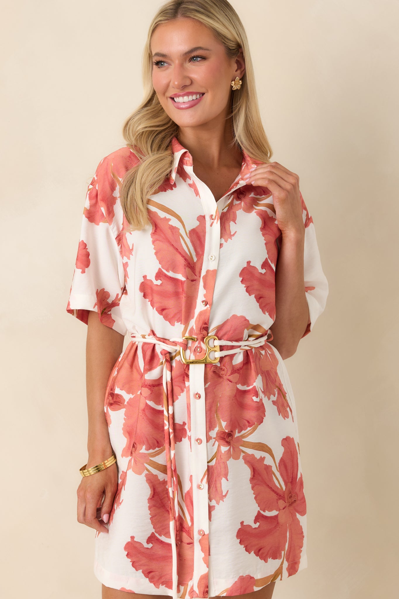 Cropped image of hibiscus print dress emphasizing the soft peach and ivory color palette and lightweight fabric.