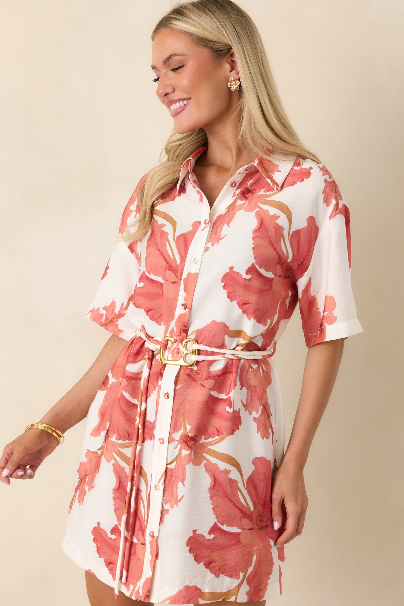Cropped view of peach floral mini dress highlighting the collared neckline and bold hibiscus print.