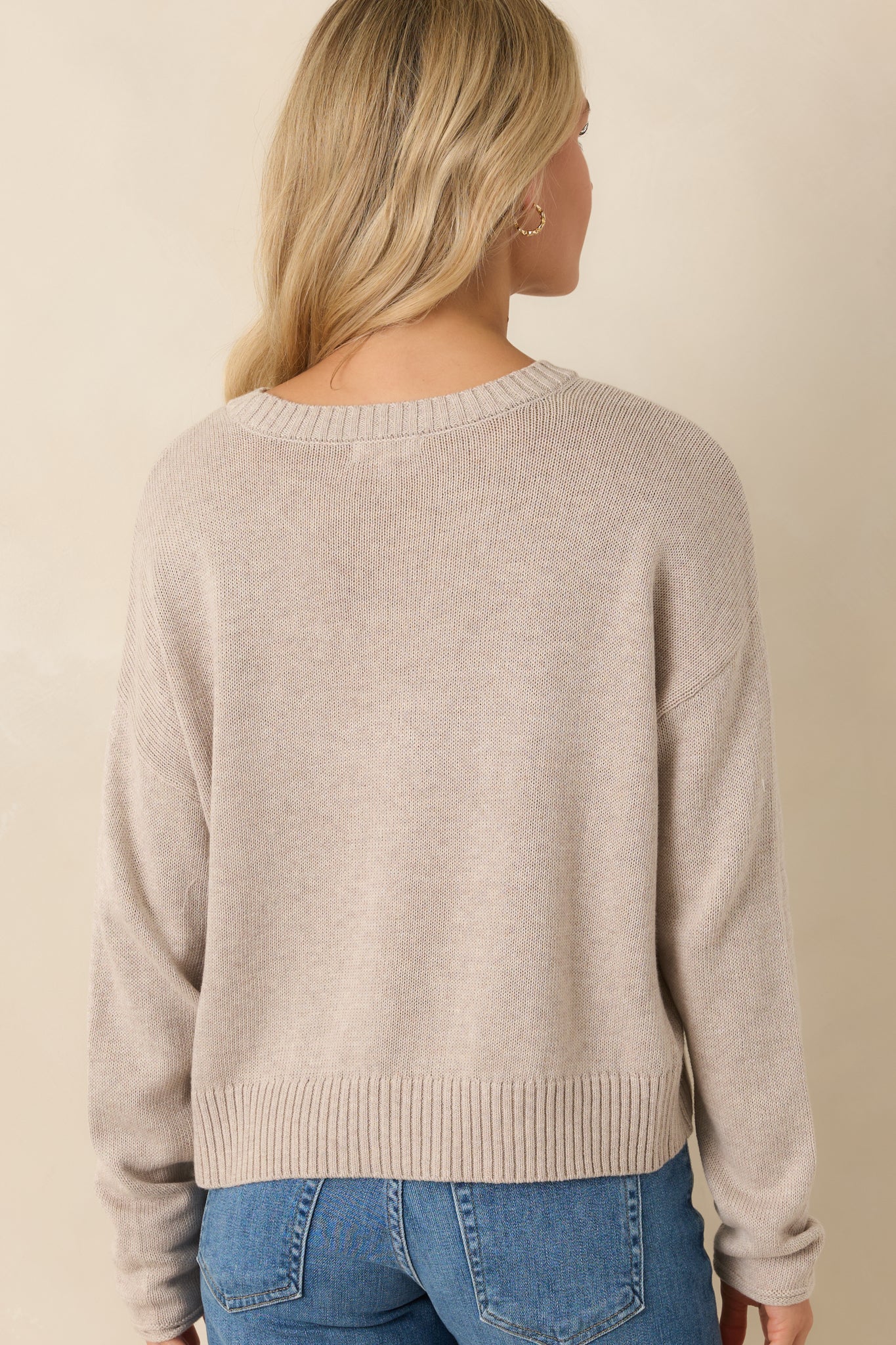 Rear view of the natural heather knit sweater featuring a relaxed fit and ribbed hem detail.