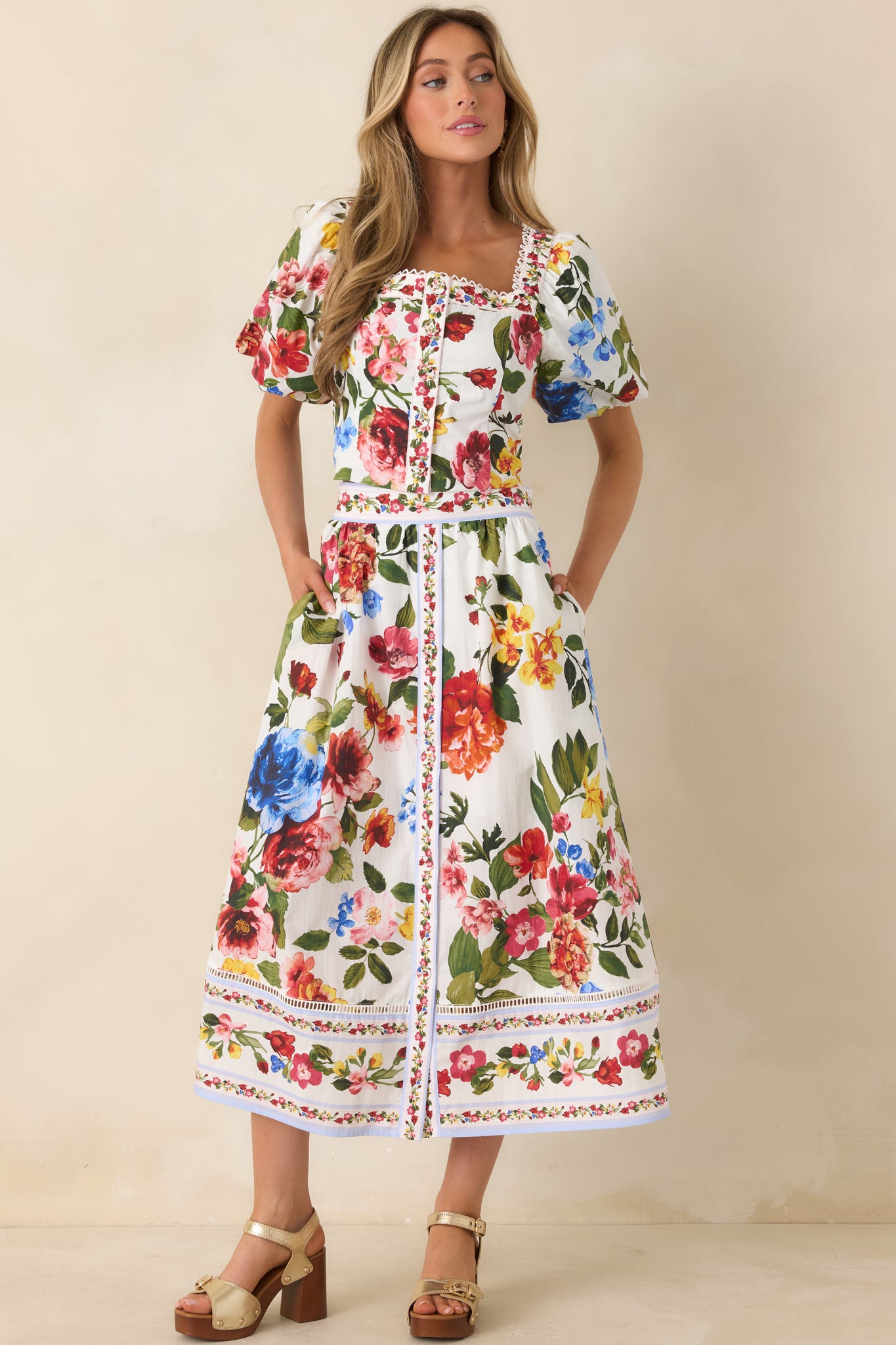 Tailored ivory top with colorful floral print and soft puff sleeves.