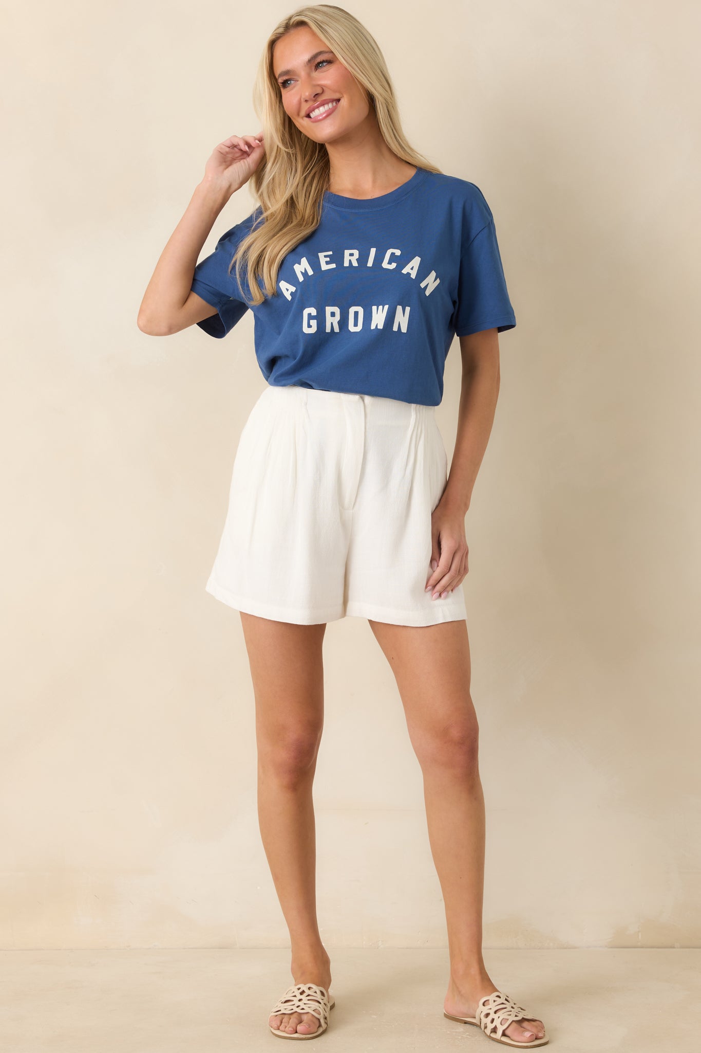 Deep blue cotton graphic tee featuring white “American Grown” lettering, a crew neckline, short sleeves, and relaxed boyfriend silhouette.