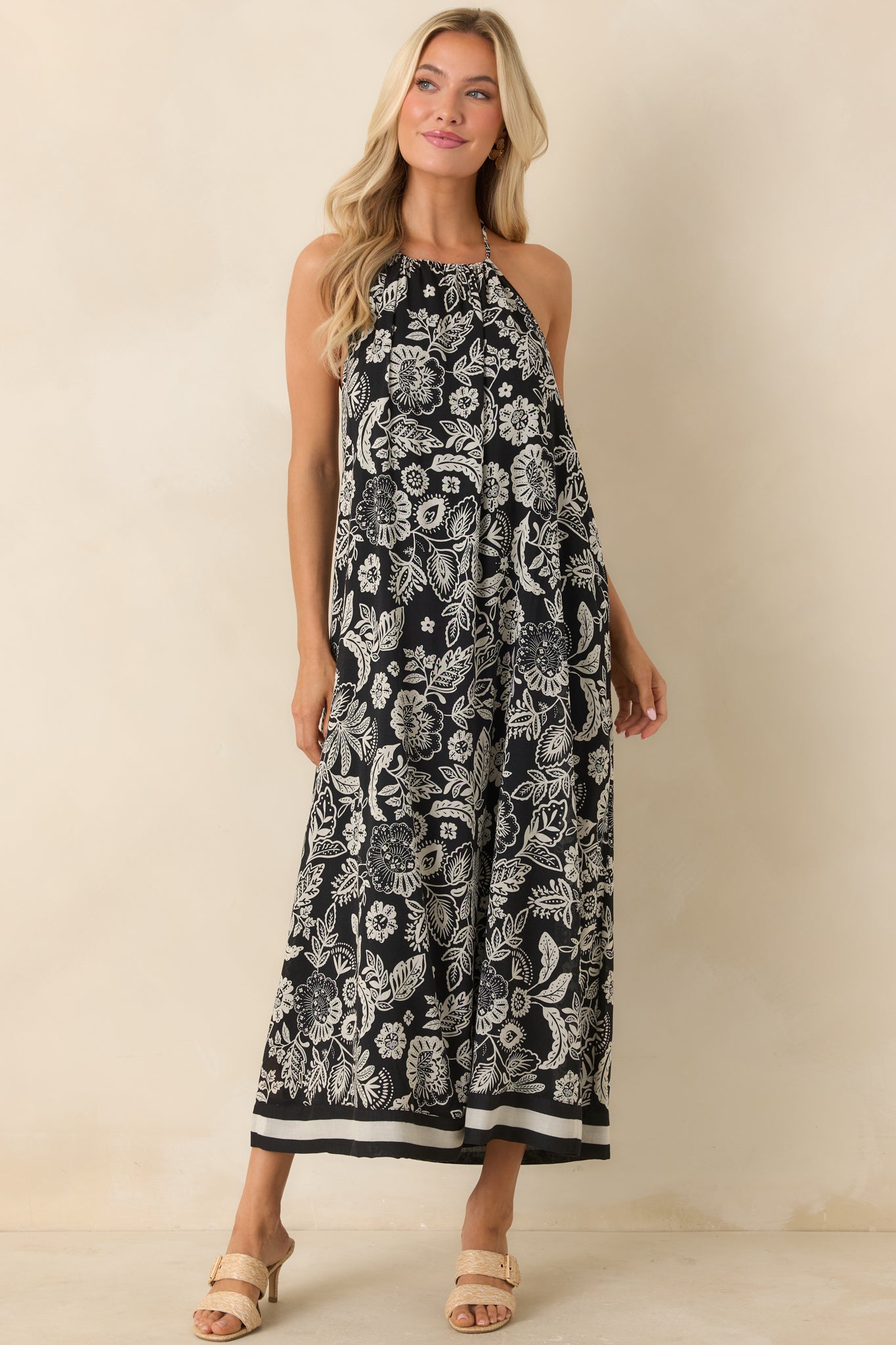 Full-length front view of black and ivory floral halter midi dress featuring a relaxed draped fit and flowing silhouette.