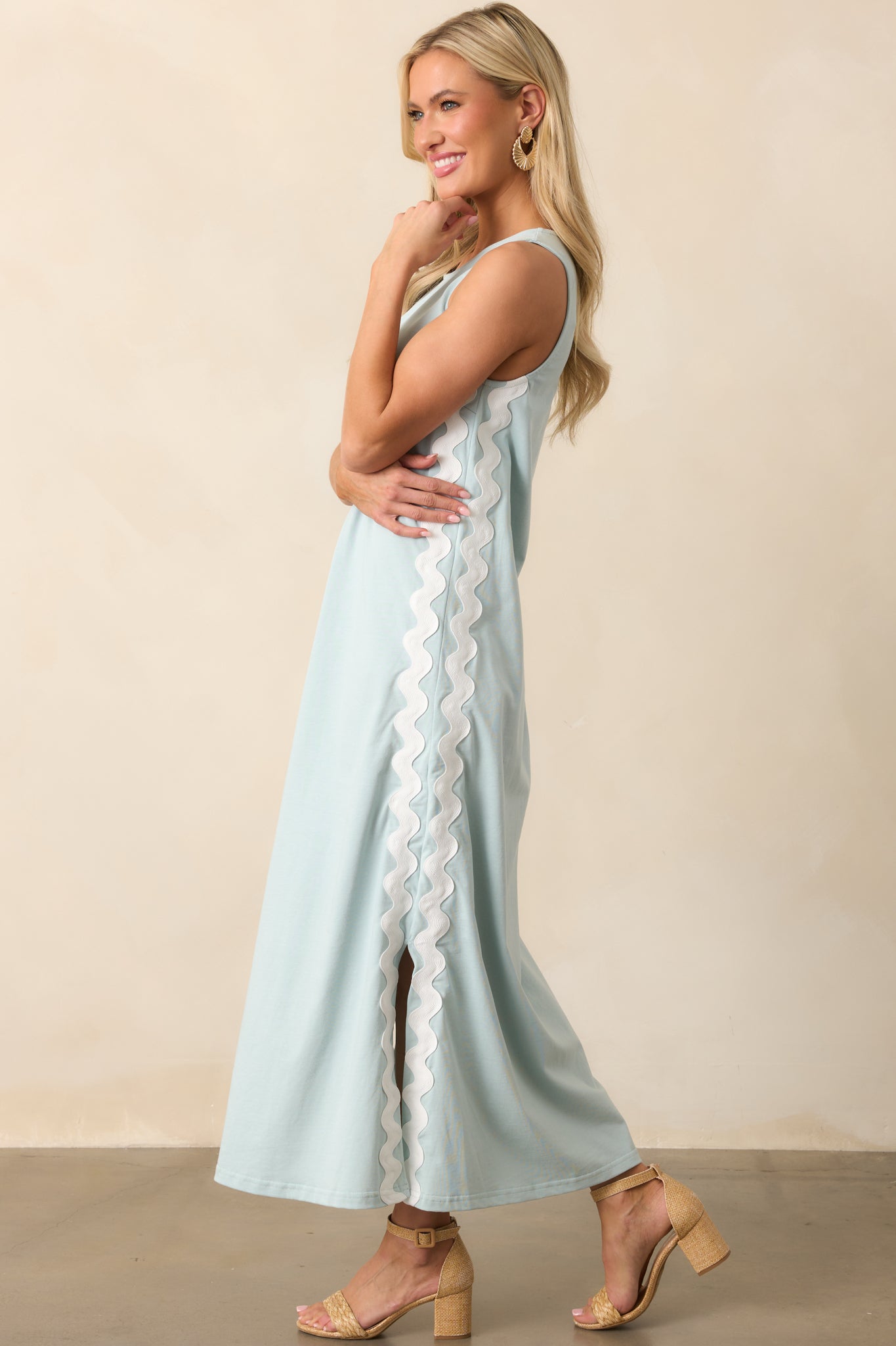 A breezy blue maxi dress with a sleeveless design, featuring a keyhole closure and vertical ric rac trim for added contrast.